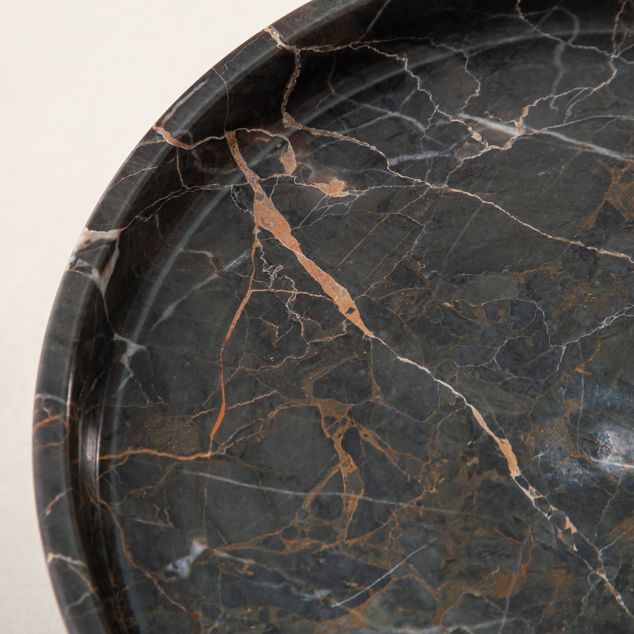 Handcrafted marble bowl with dark tones and warm veining also usable as elegant cake stand
