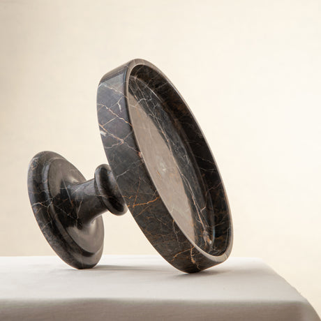 Handcrafted marble bowl with dark tones and warm veining also usable as elegant cake stand
