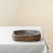 Unique marble bowl with raw textured exterior and polished fossil patterned interior
