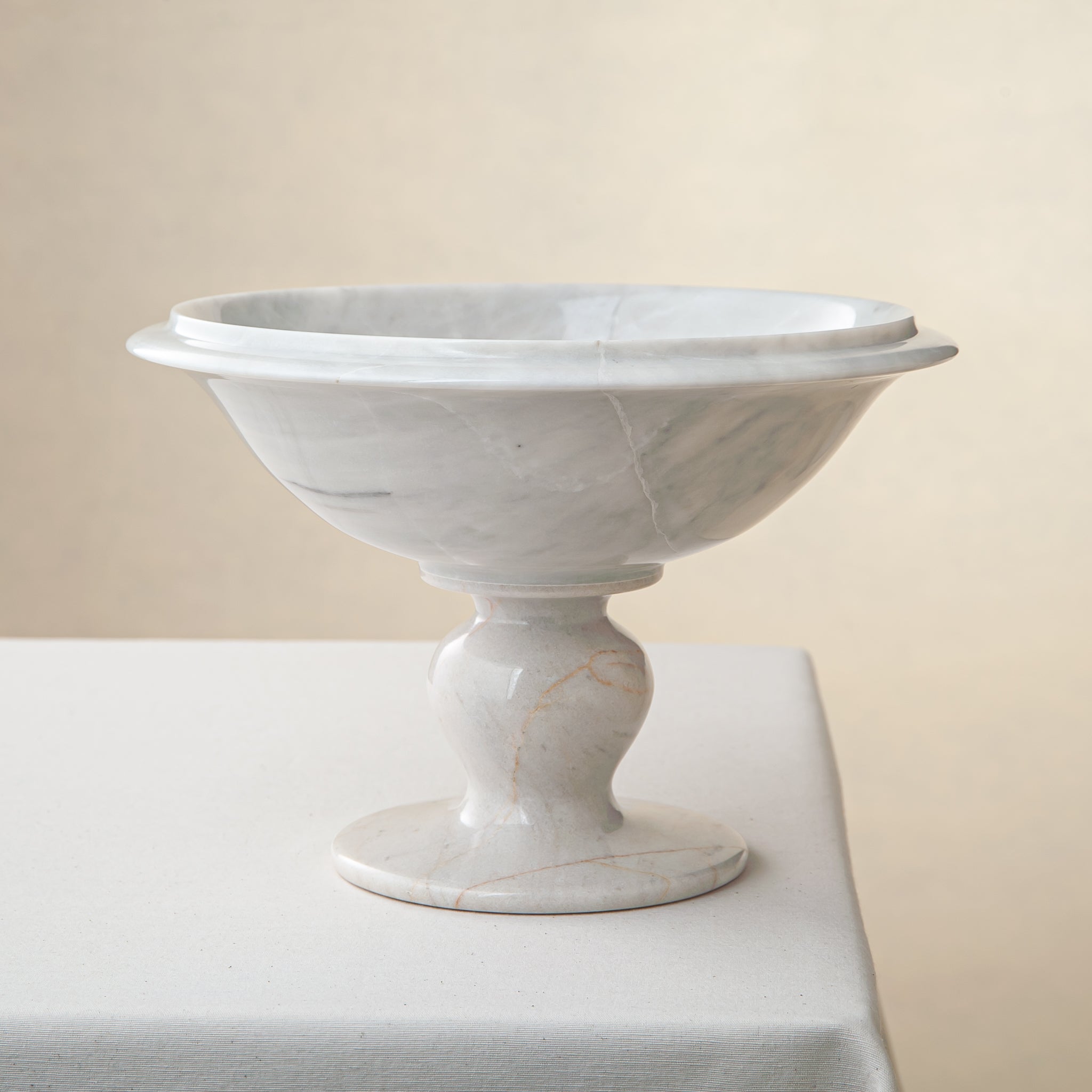 handcrafted marble bowl with white surface and subtle grey veining on pedestal for luxury decor
