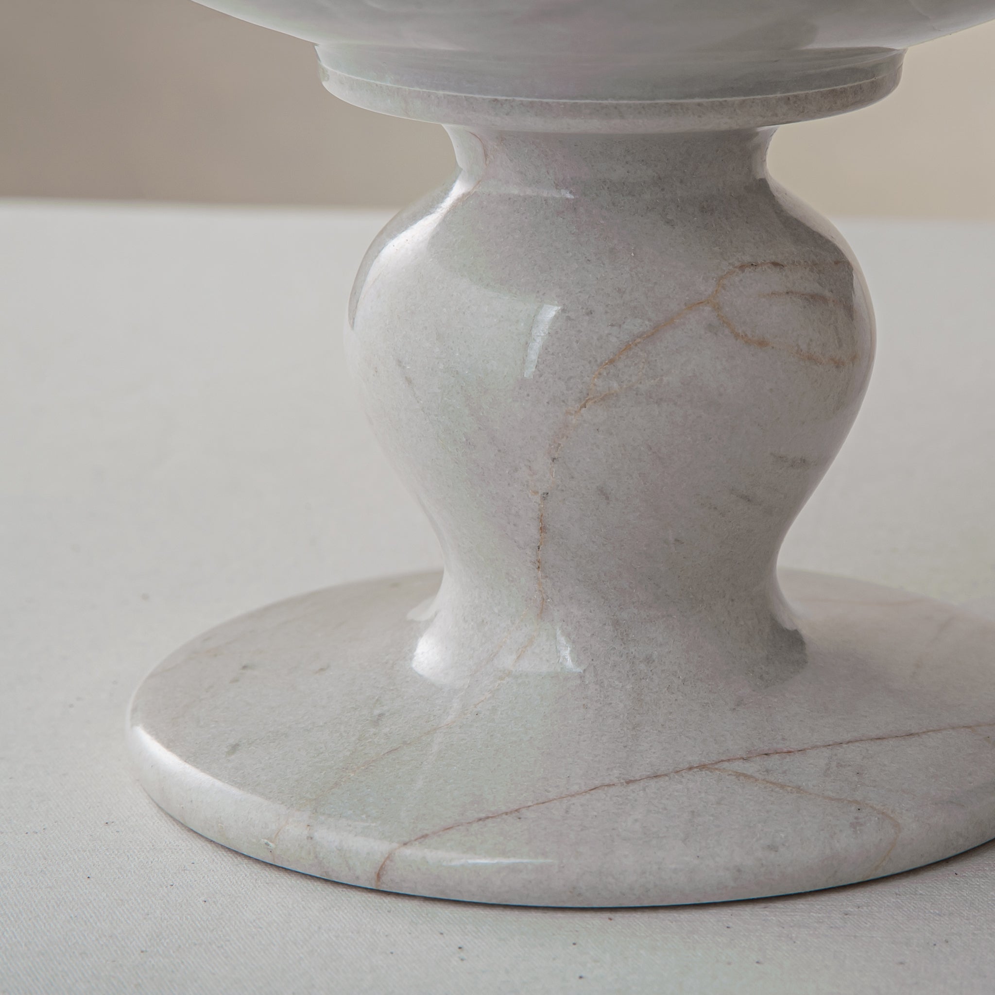 handcrafted marble bowl with white surface and subtle grey veining on pedestal for luxury decor
