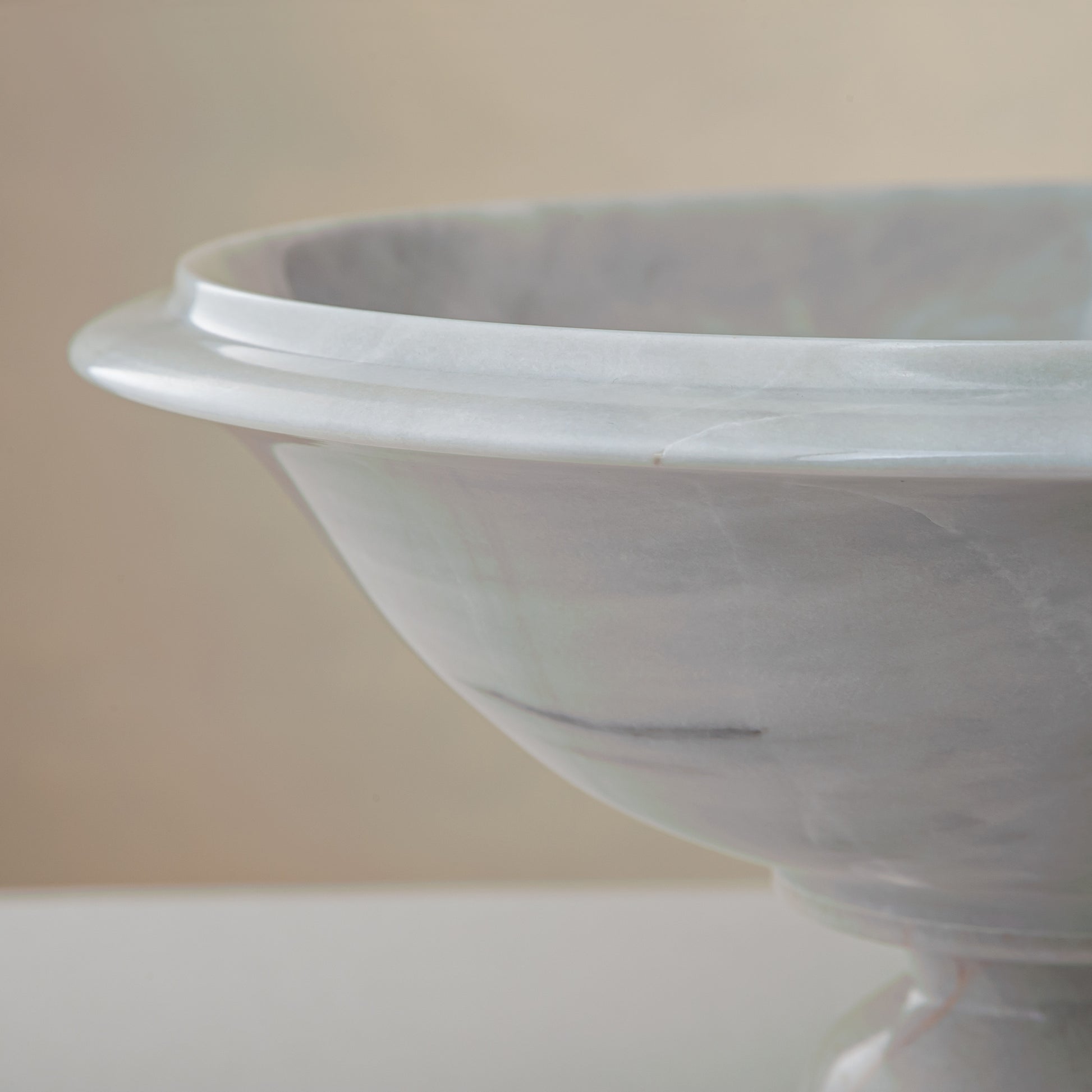 handcrafted marble bowl with white surface and subtle grey veining on pedestal for luxury decor
