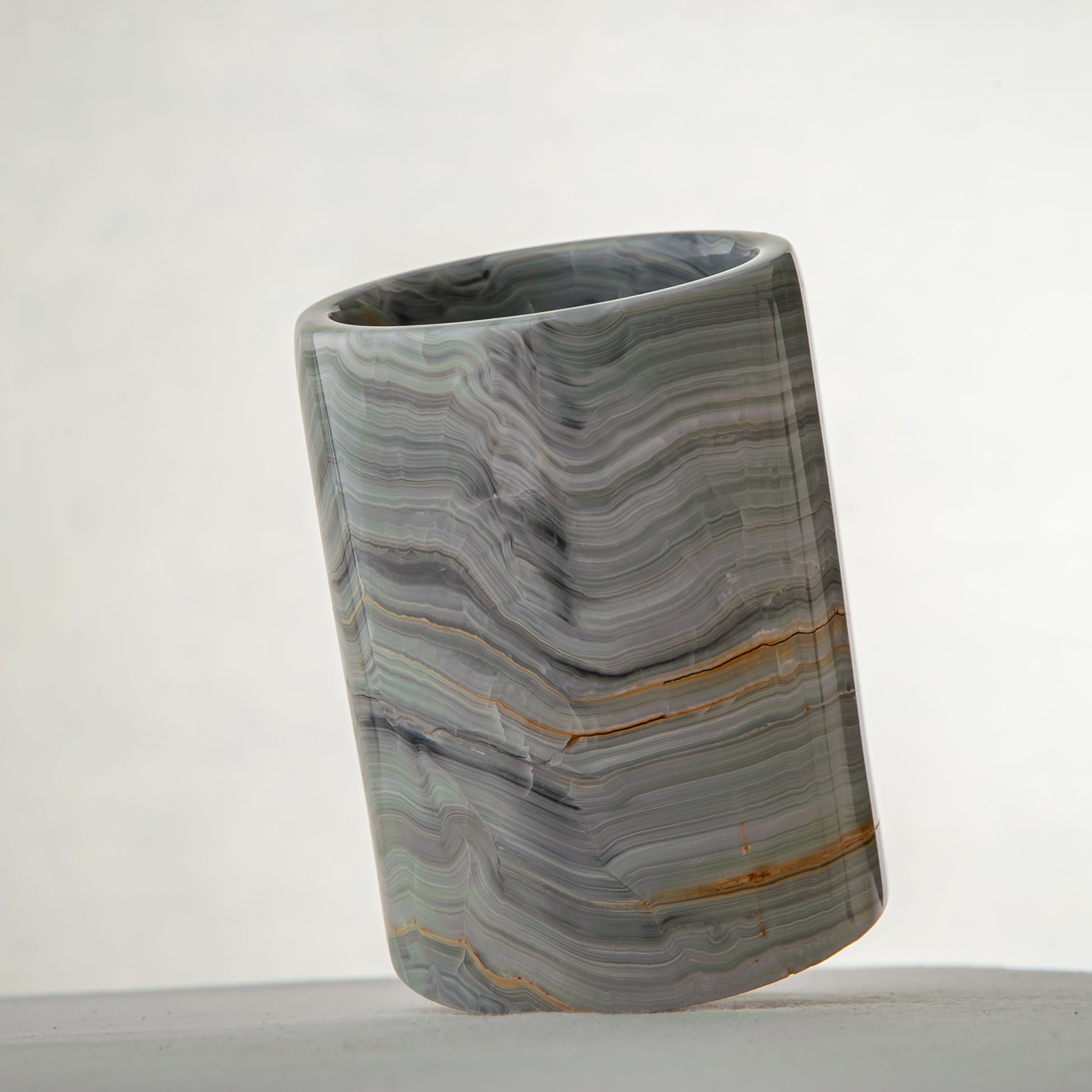 artisanal onyx vase with smooth polished surface and flowing veining patterns
