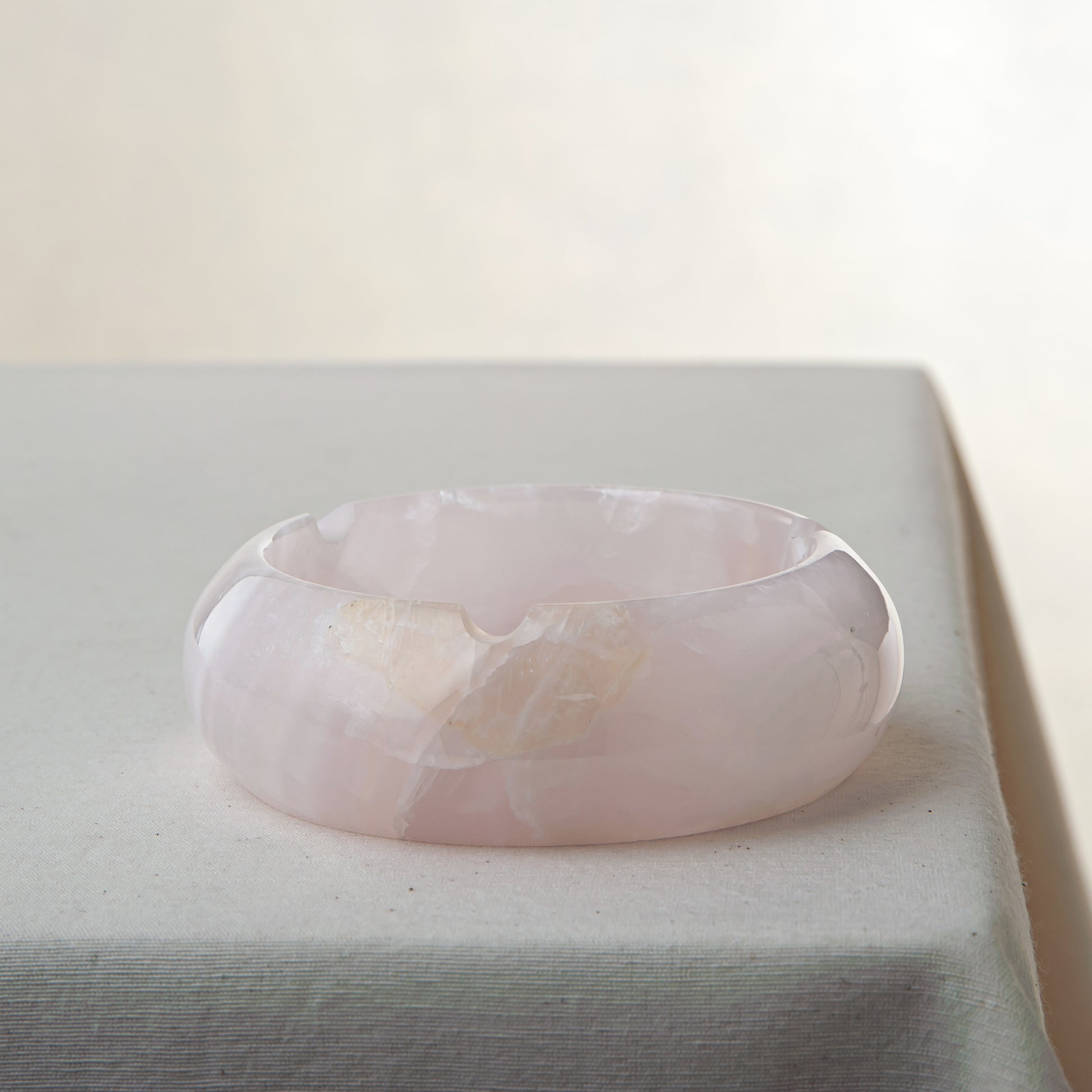 Handcrafted rose onyx ash tray with soft pink tones and smooth sculptural form for elegant table decor
