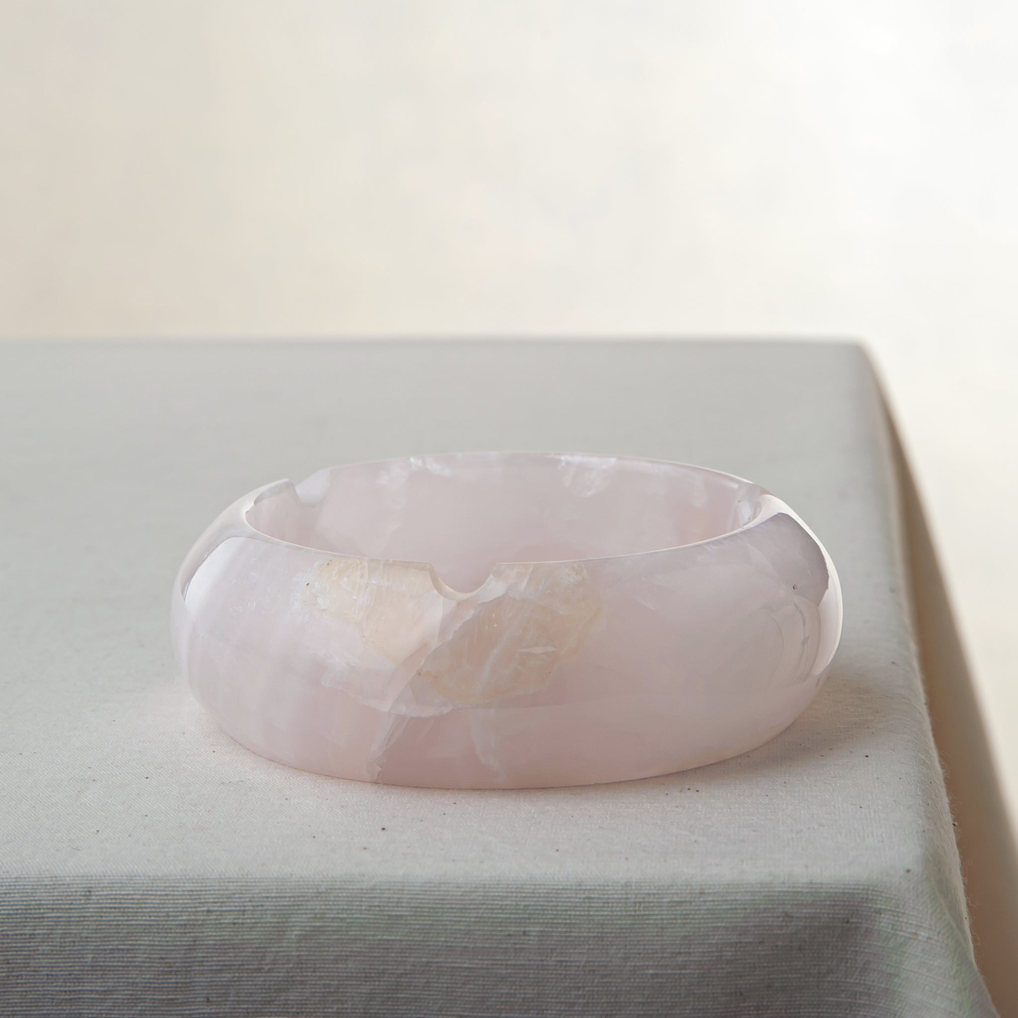 Handcrafted rose onyx ash tray with soft pink tones and smooth sculptural form for elegant table decor
