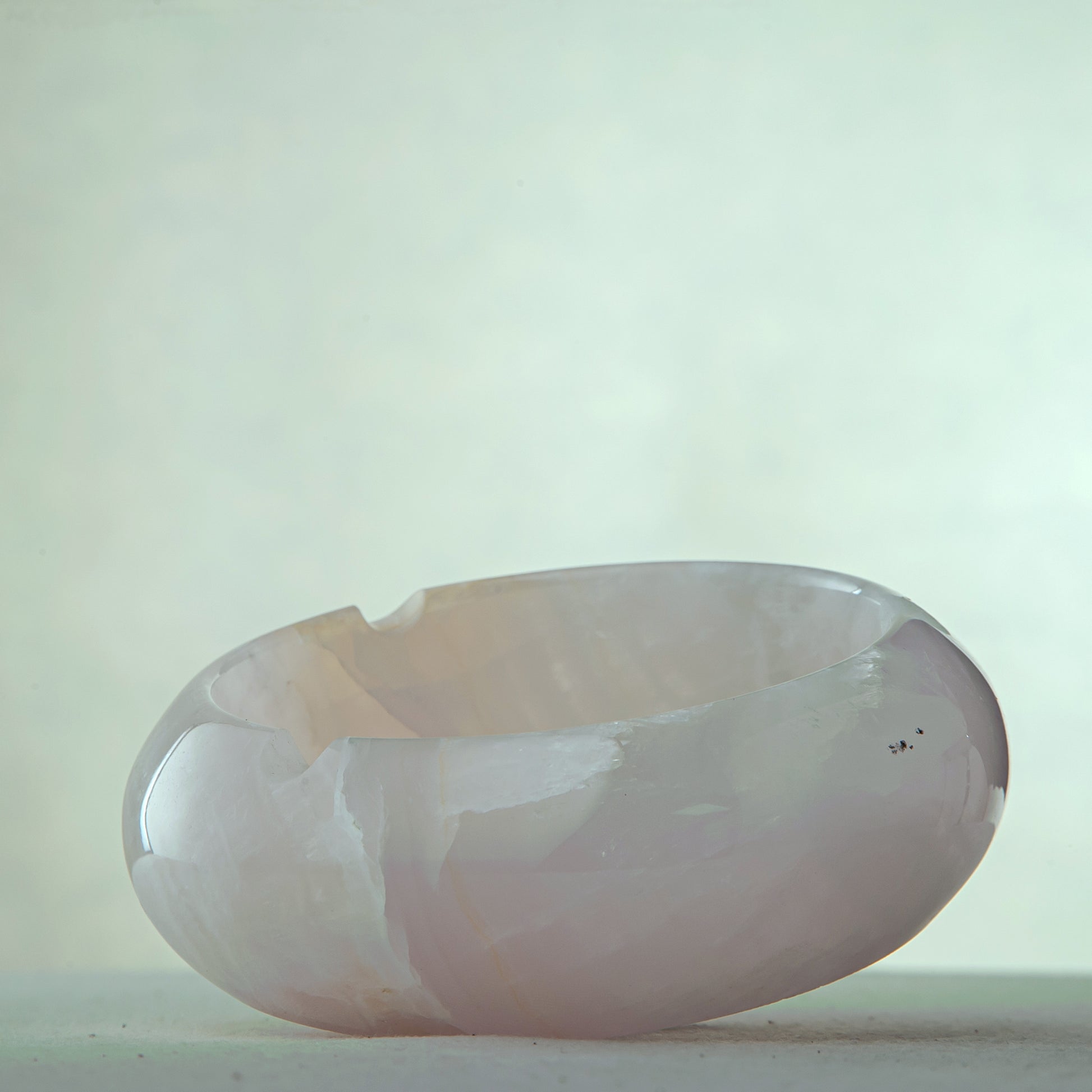 Handcrafted rose onyx ash tray with soft pink tones and smooth sculptural form for elegant table decor
