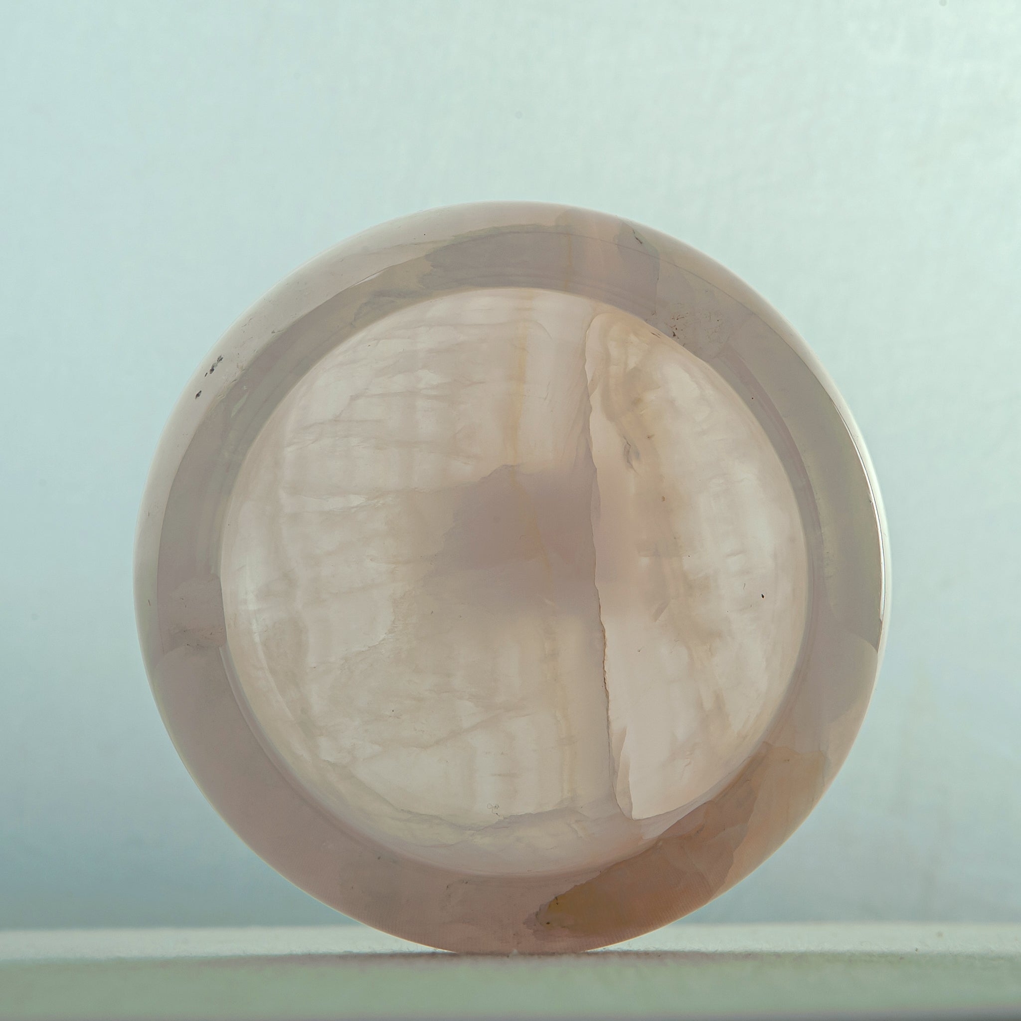 Handcrafted rose onyx ash tray with soft pink tones and smooth sculptural form for elegant table decor
