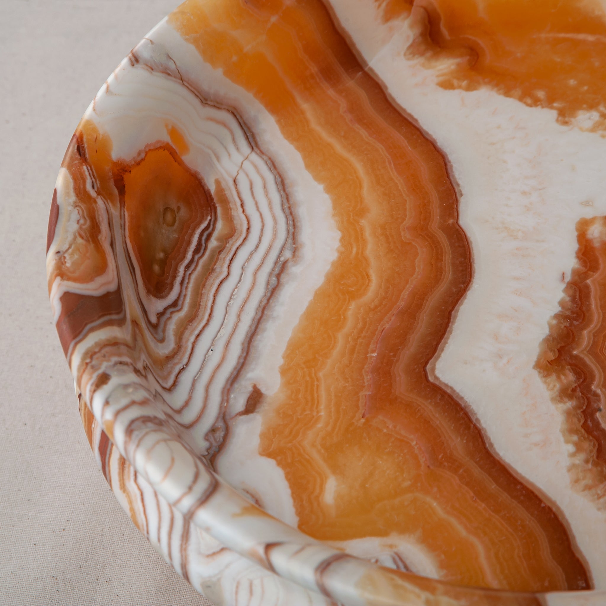 unique natural onyx bowl with warm honey coloration and sculptural pedestal as centerpiece
