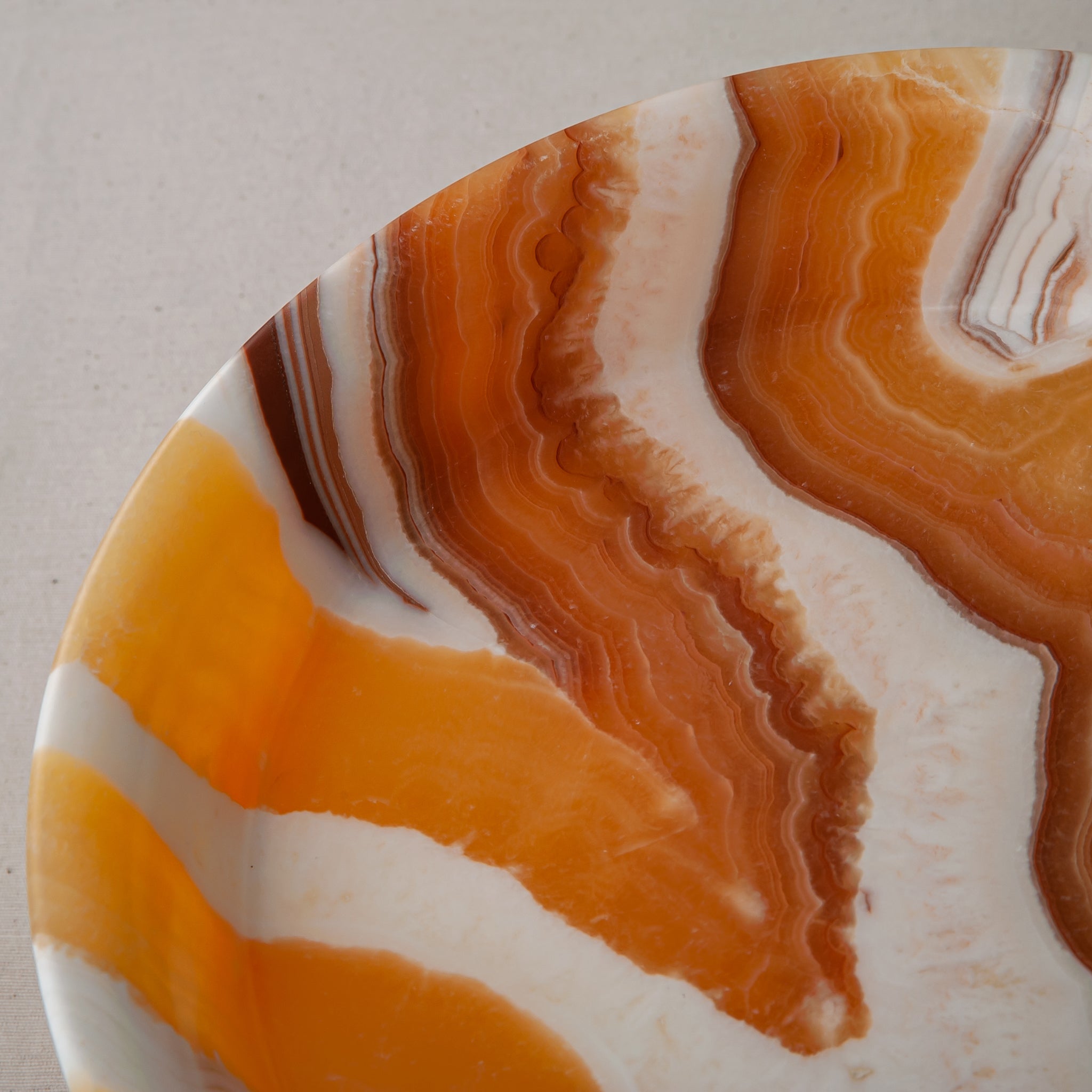 unique natural onyx bowl with warm honey coloration and sculptural pedestal as centerpiece

