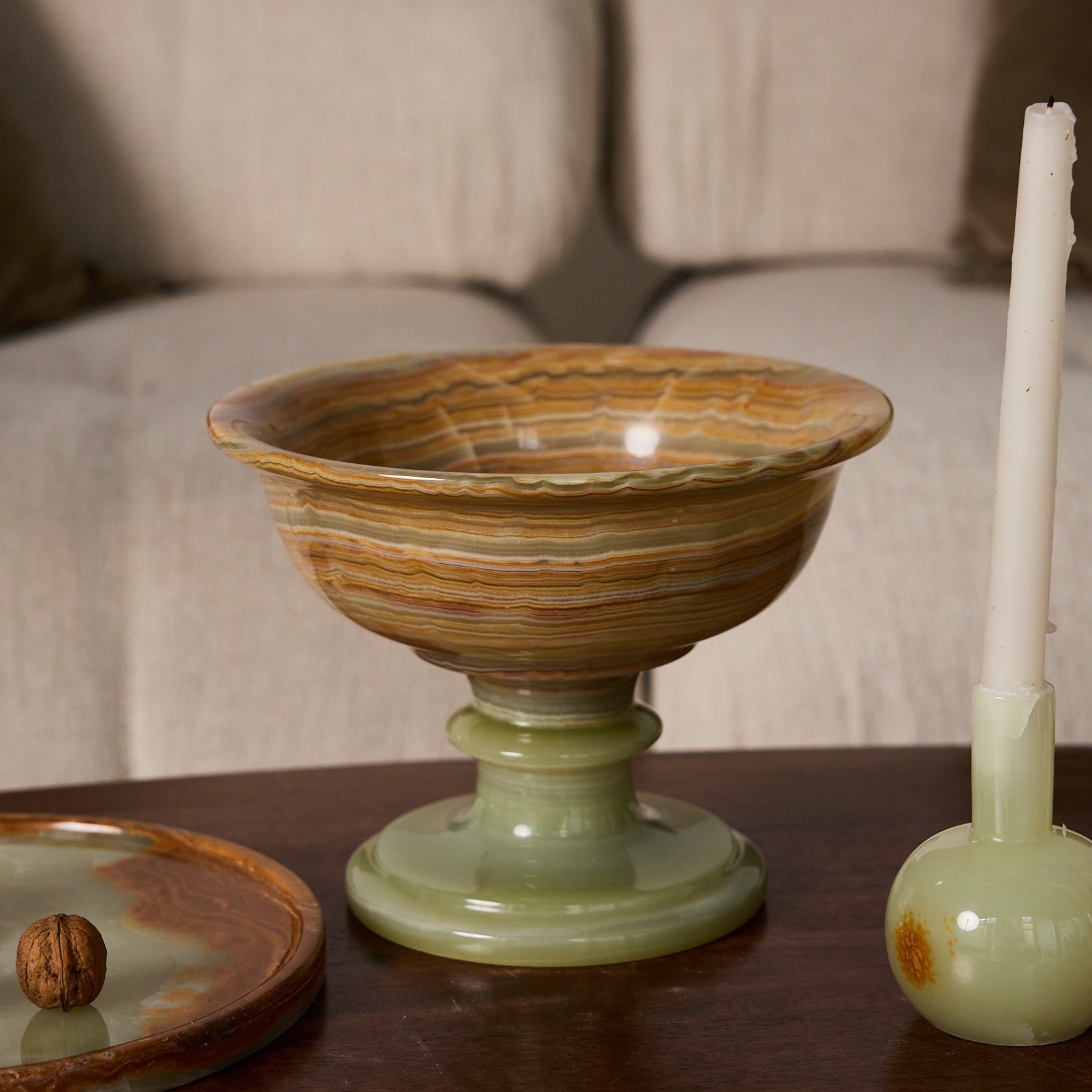 Handcrafted onyx bowl with pedestal base in warm amber veining as sculptural centerpiece
