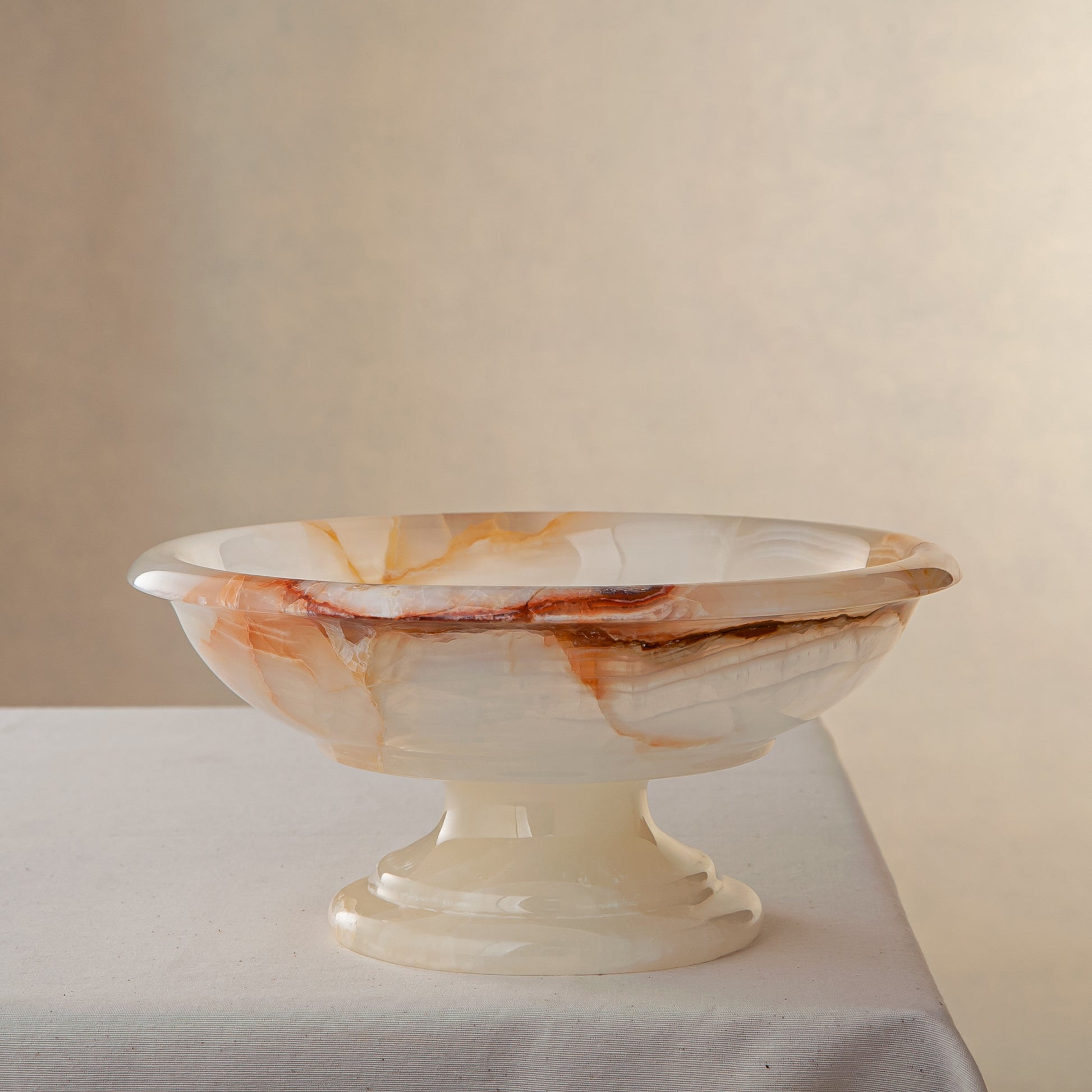 handcrafted onyx bowl with amber veining and translucent ivory stone on pedestal for luxury decor

