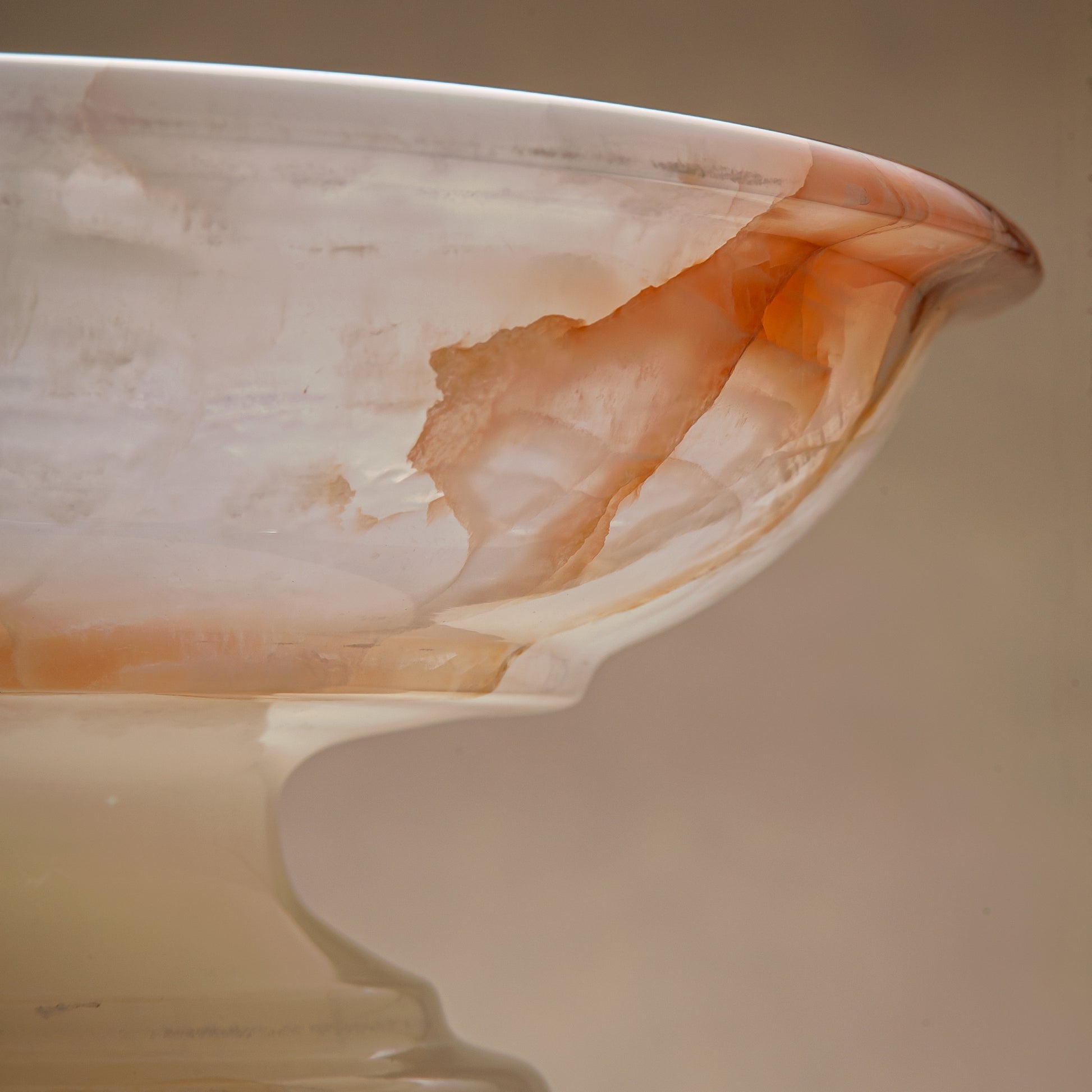 handcrafted onyx bowl with amber veining and translucent ivory stone on pedestal for luxury decor
