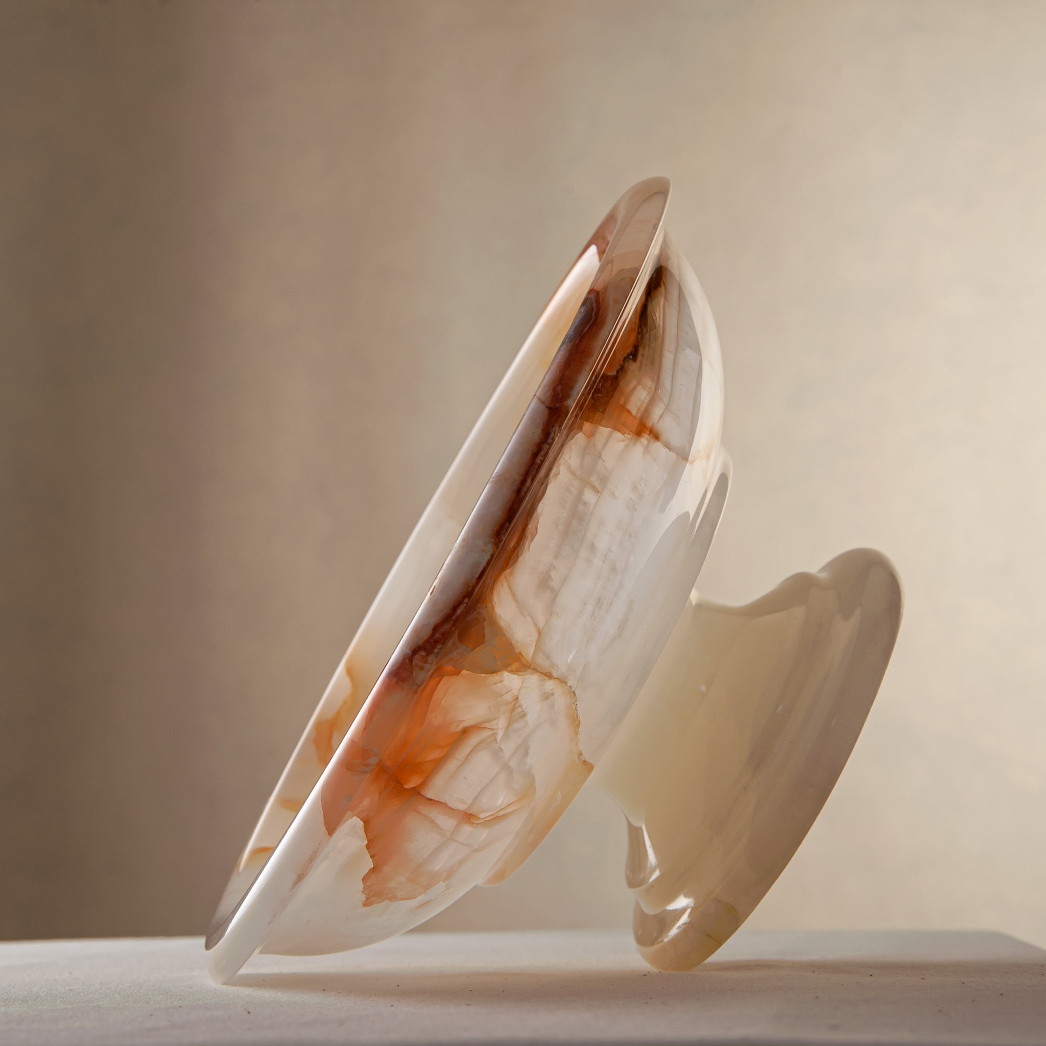 handcrafted onyx bowl with amber veining and translucent ivory stone on pedestal for luxury decor

