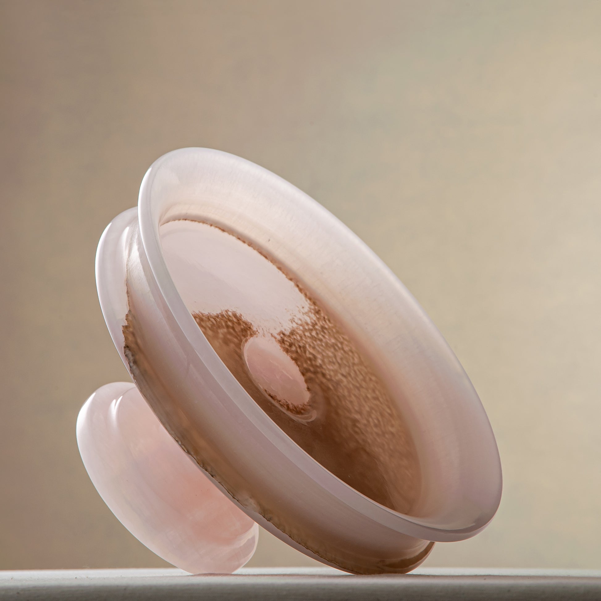 handcrafted onyx bowl with blush pink tones and translucent layered stone on pedestal for luxury decor
