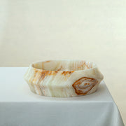 handcrafted onyx bowl with faceted edge and ivory tones with amber veining for luxury decor

