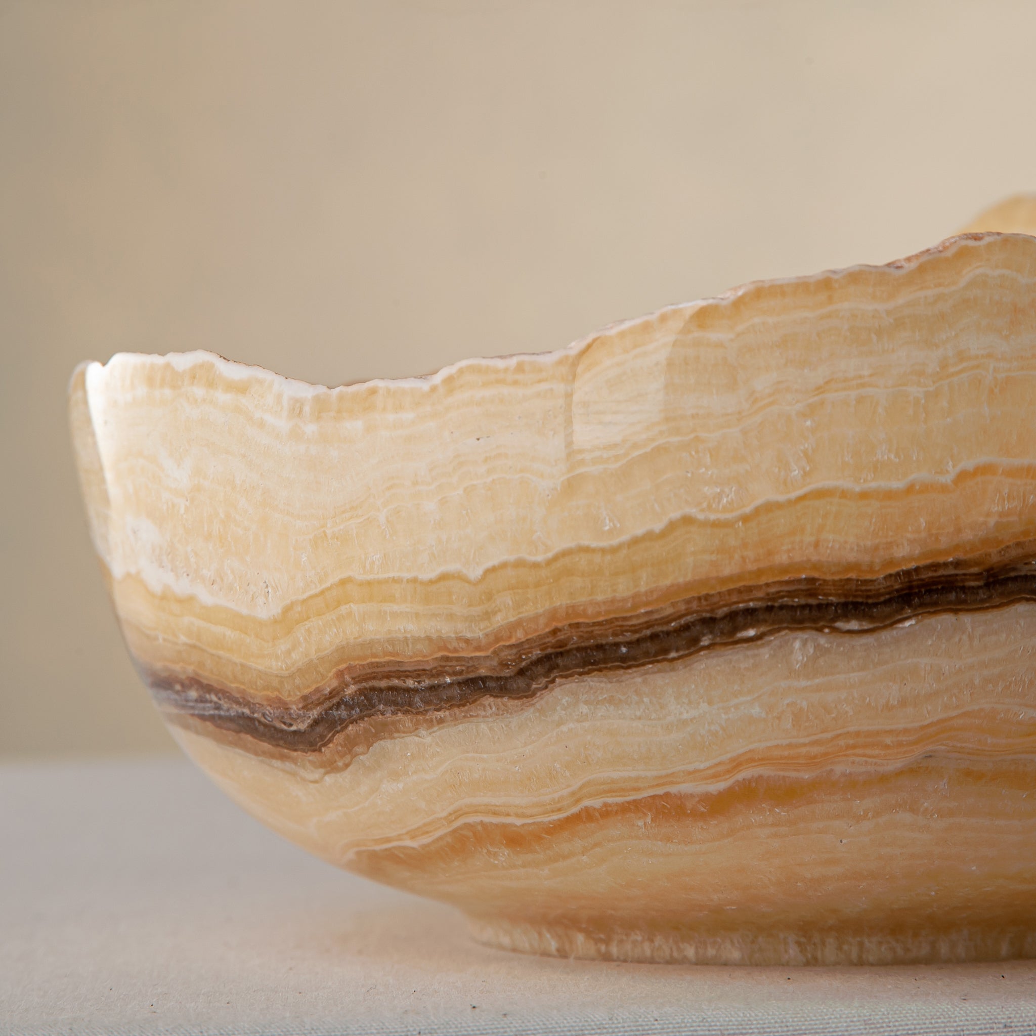 handcrafted onyx bowl with golden amber layers and organic asymmetrical rim for luxury decor
