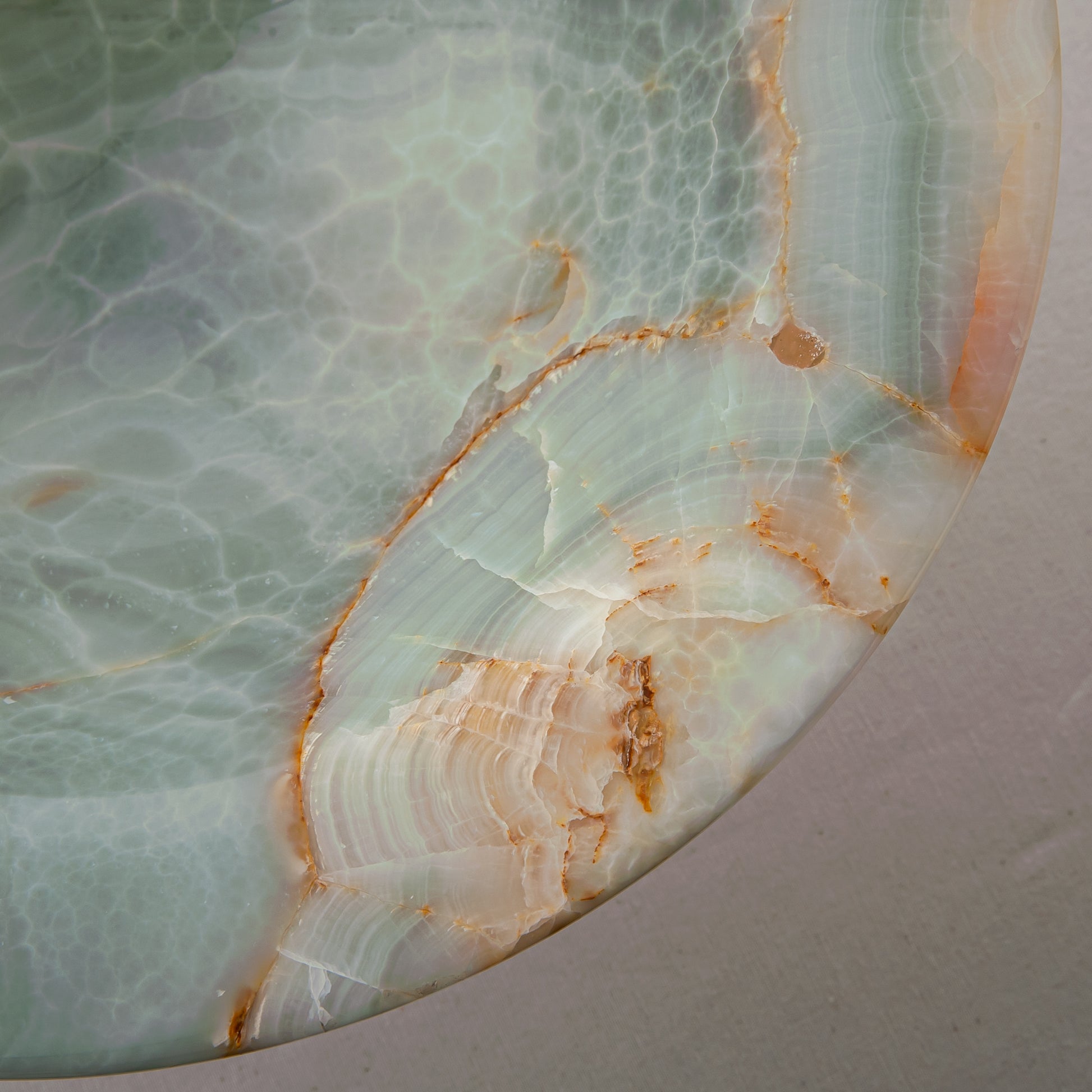 handcrafted green onyx bowl with amber veining and translucent surface for luxury decor
