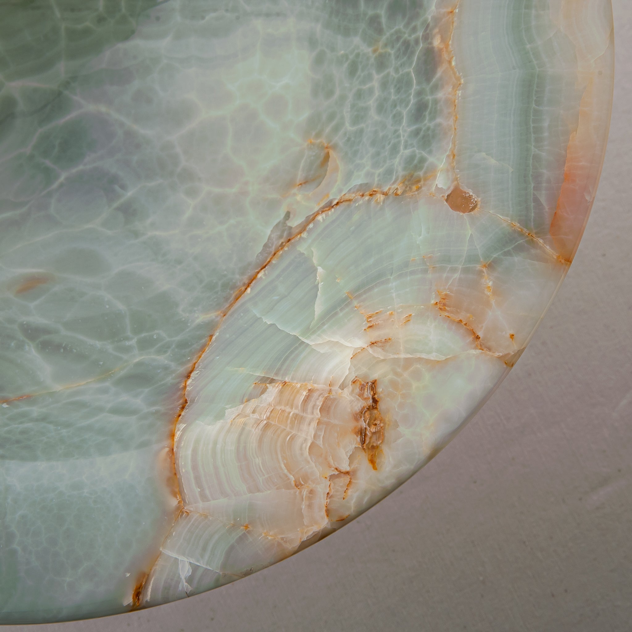 handcrafted green onyx bowl with amber veining and translucent surface for luxury decor
