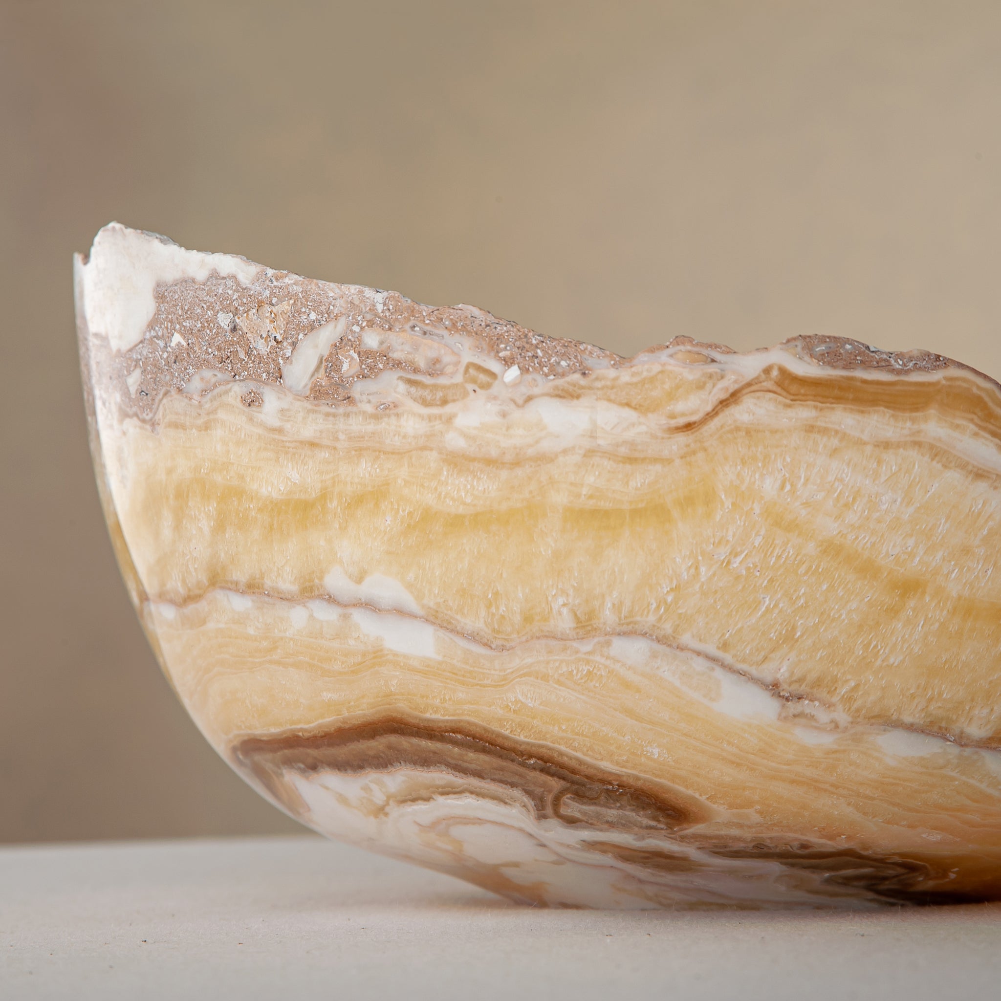 artisanal onyx bowl with translucent amber tones and irregular rim for coffee table styling
