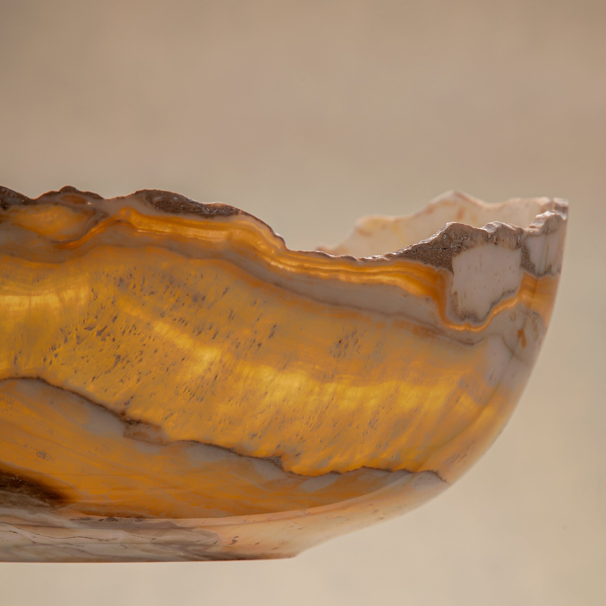 artisanal onyx bowl with translucent amber tones and irregular rim for coffee table styling
