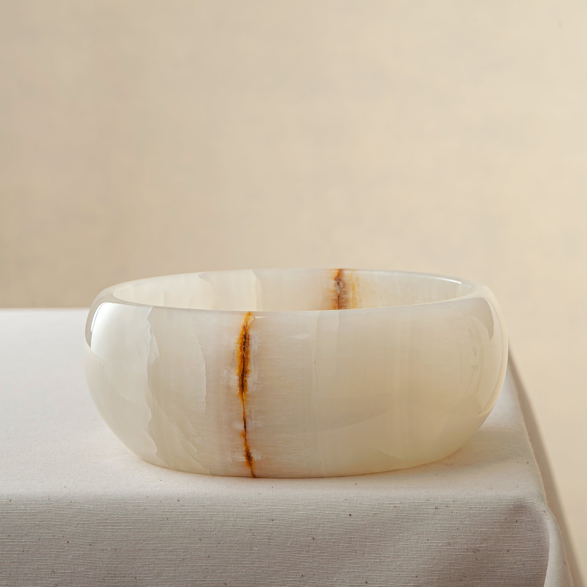 handcrafted onyx bowl with ivory surface and bold amber vein for luxury centerpiece
