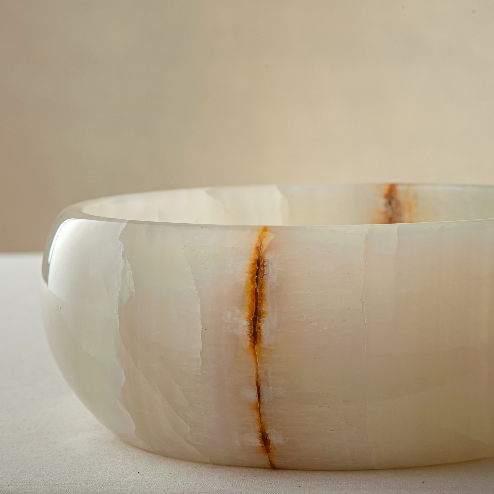 unique natural onyx bowl with smooth polished finish and warm vertical veining
