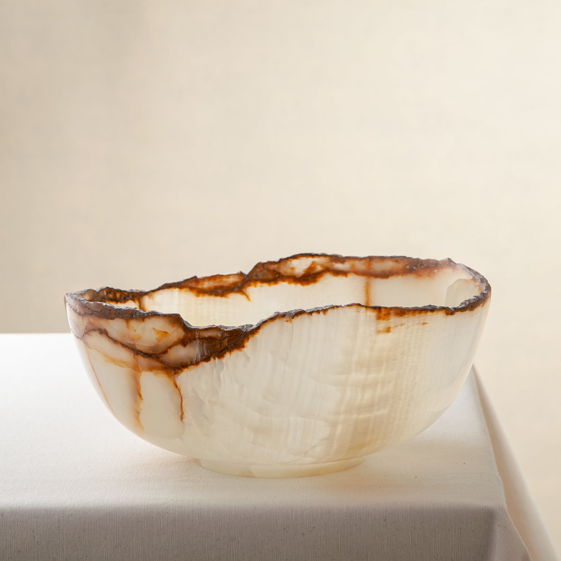 handcrafted onyx bowl with ivory translucency and amber veining with organic edge for luxury decor
