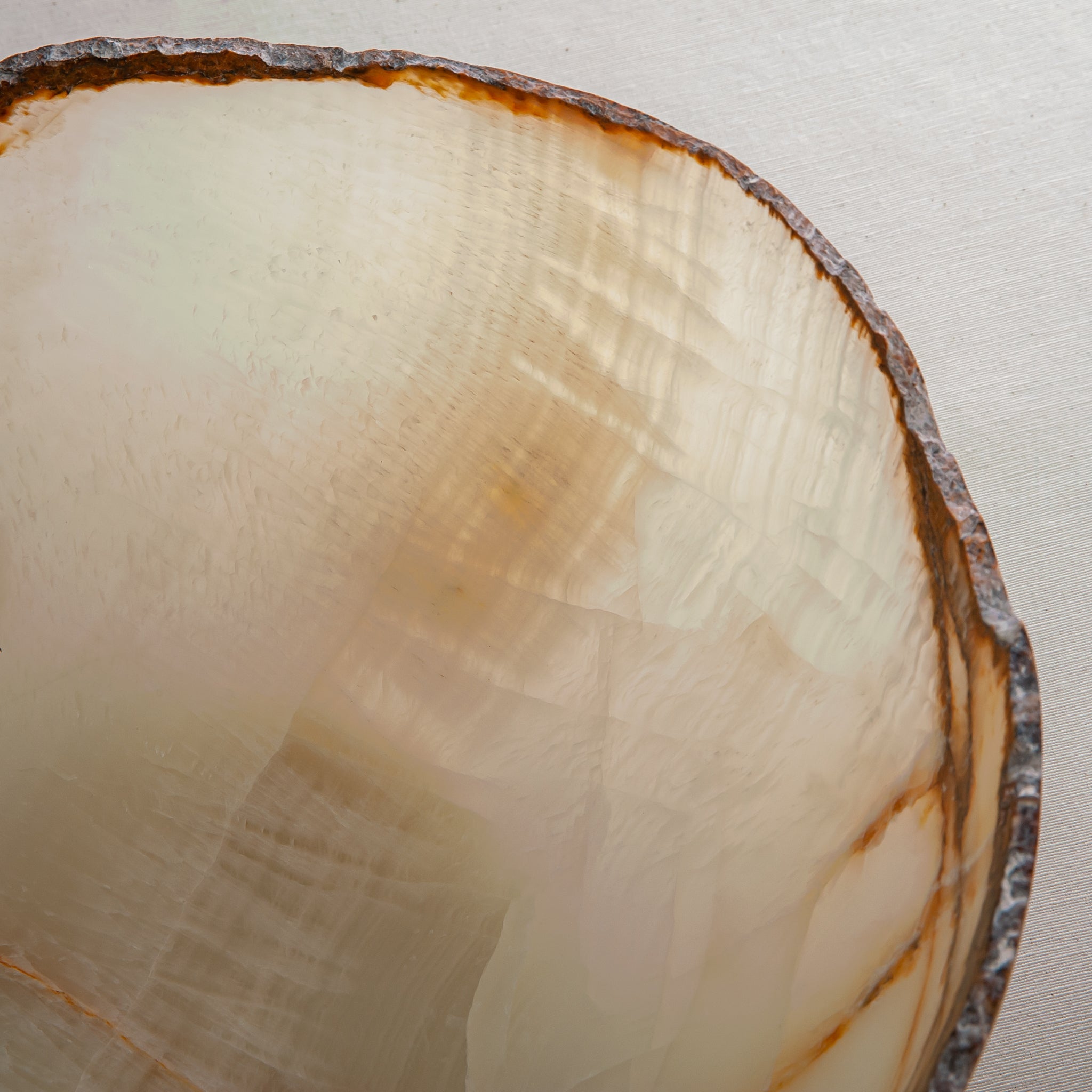 handcrafted onyx bowl with ivory translucency and amber veining with organic edge for luxury decor
