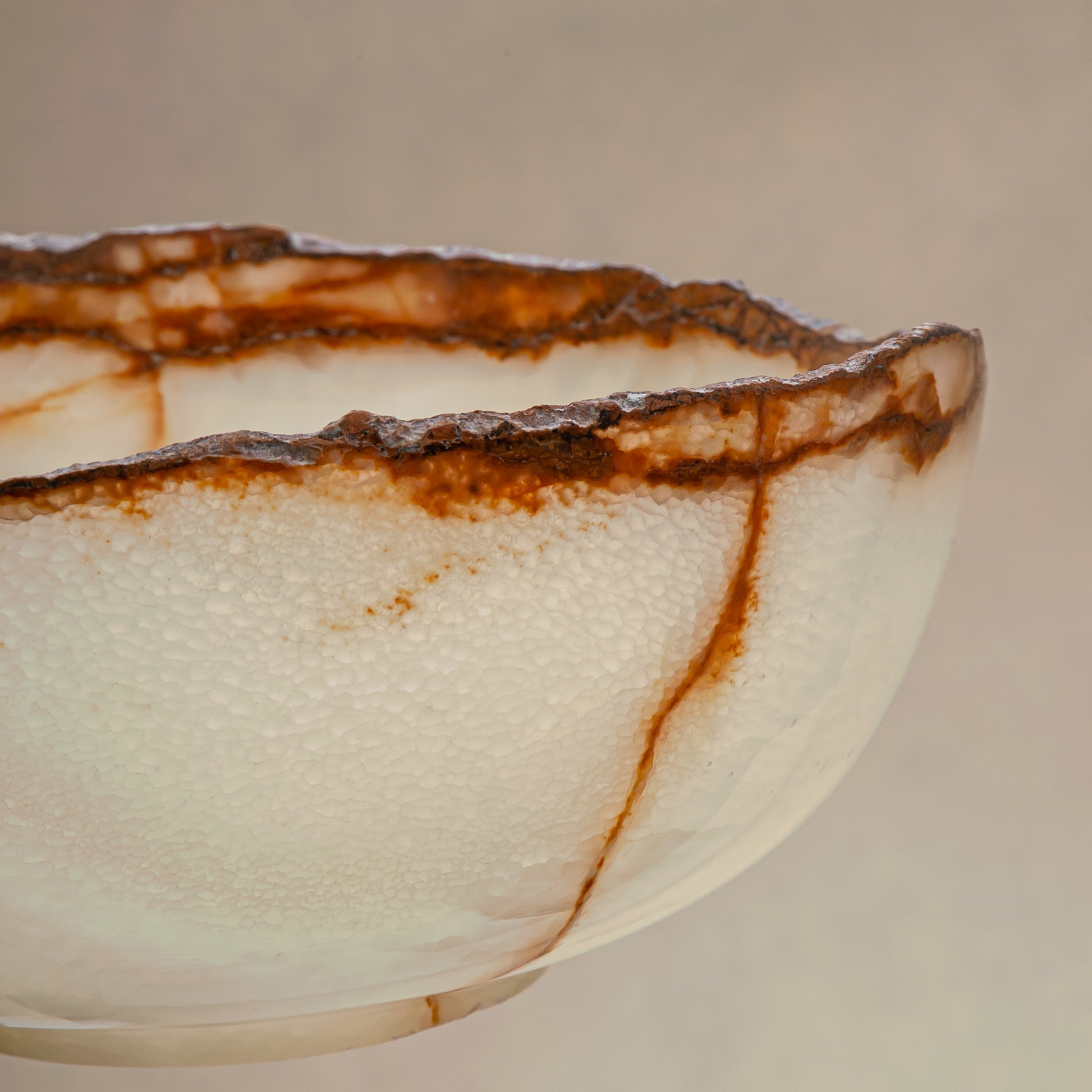 handcrafted onyx bowl with ivory translucency and amber veining with organic edge for luxury decor
