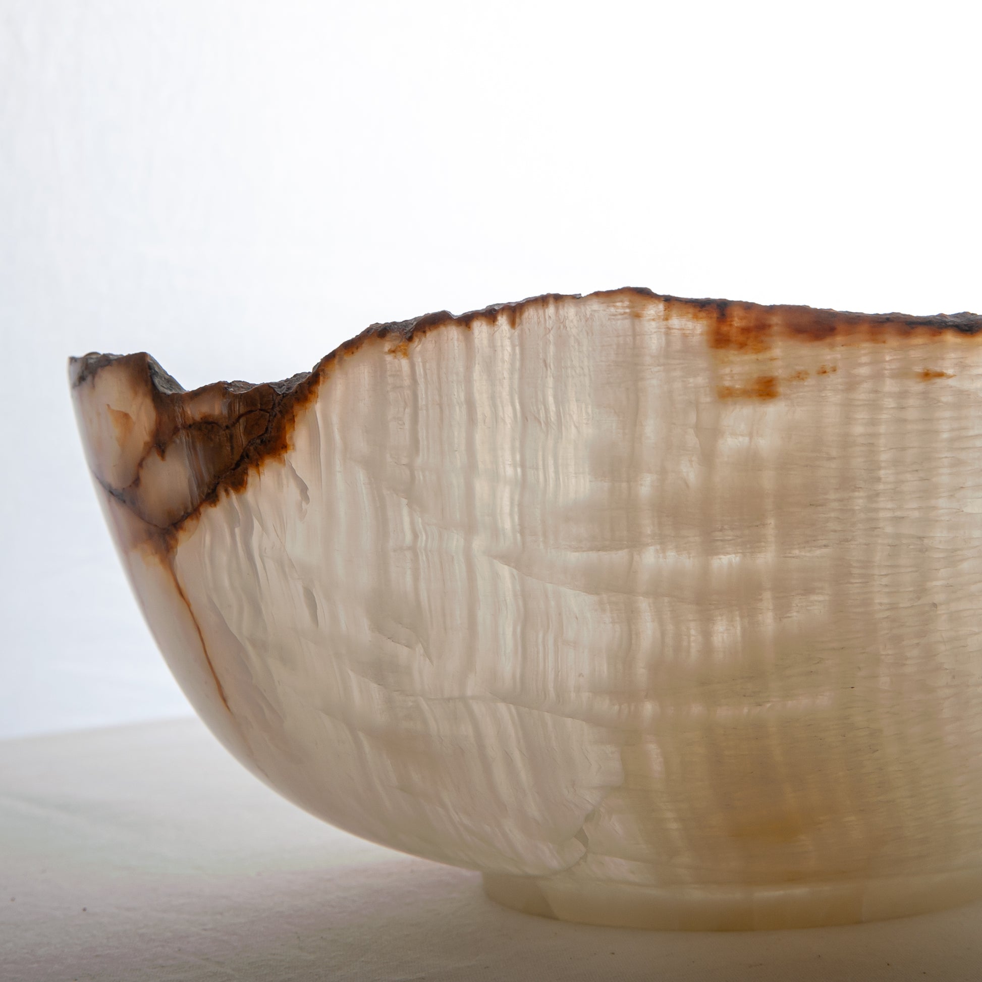 handcrafted onyx bowl with ivory translucency and amber veining with organic edge for luxury decor
