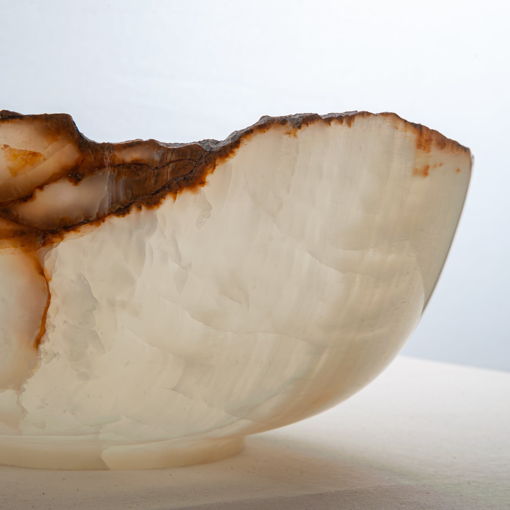 handcrafted onyx bowl with ivory translucency and amber veining with organic edge for luxury decor
