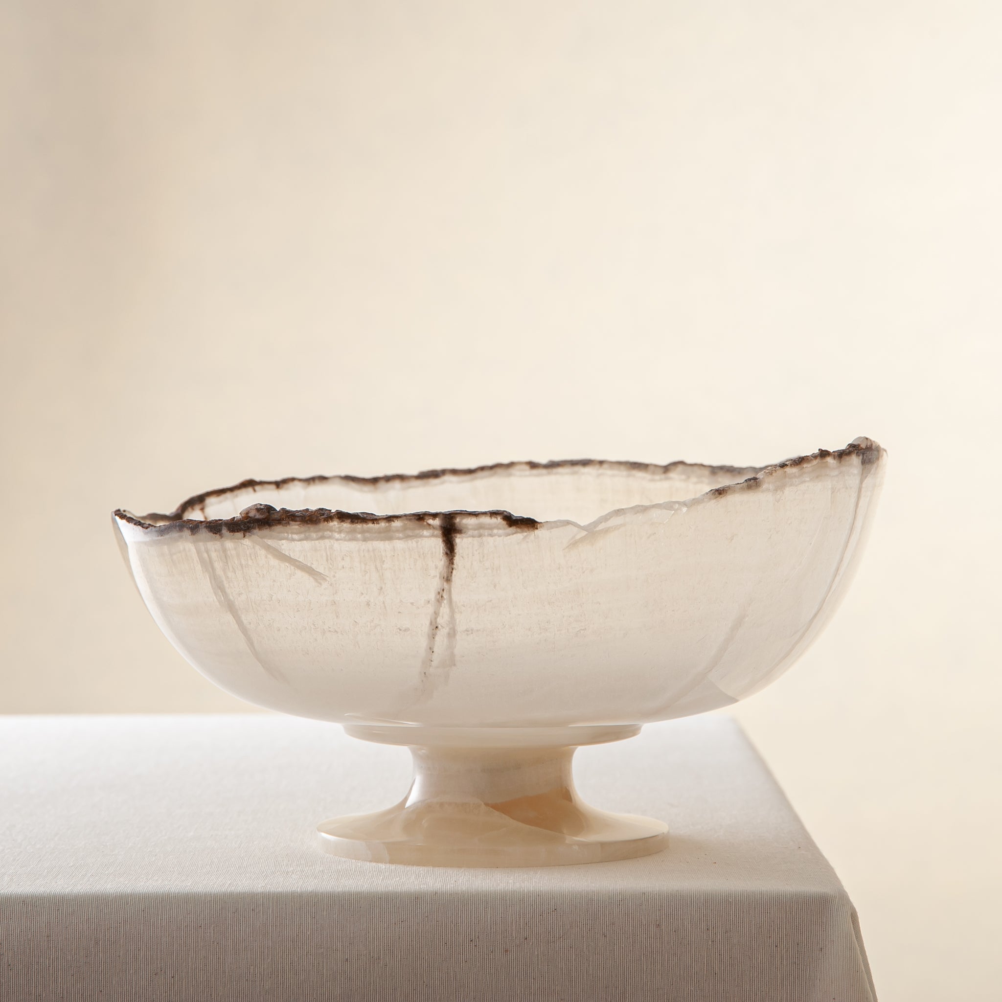 handcrafted onyx bowl in translucent ivory stone with natural rugged edge for luxury decor
