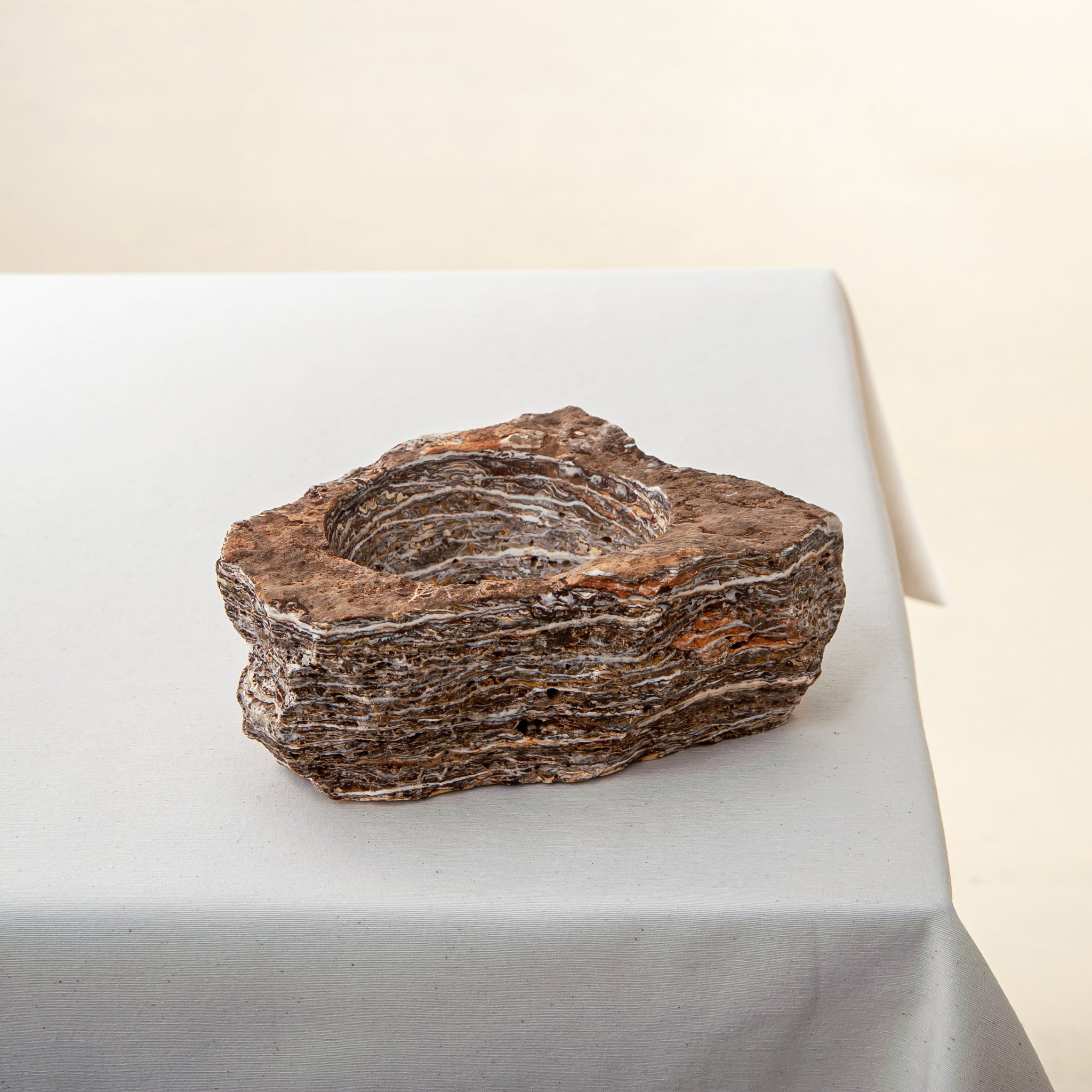 handcrafted onyx bowl with layered brown and ivory bands as sculptural centerpiece
