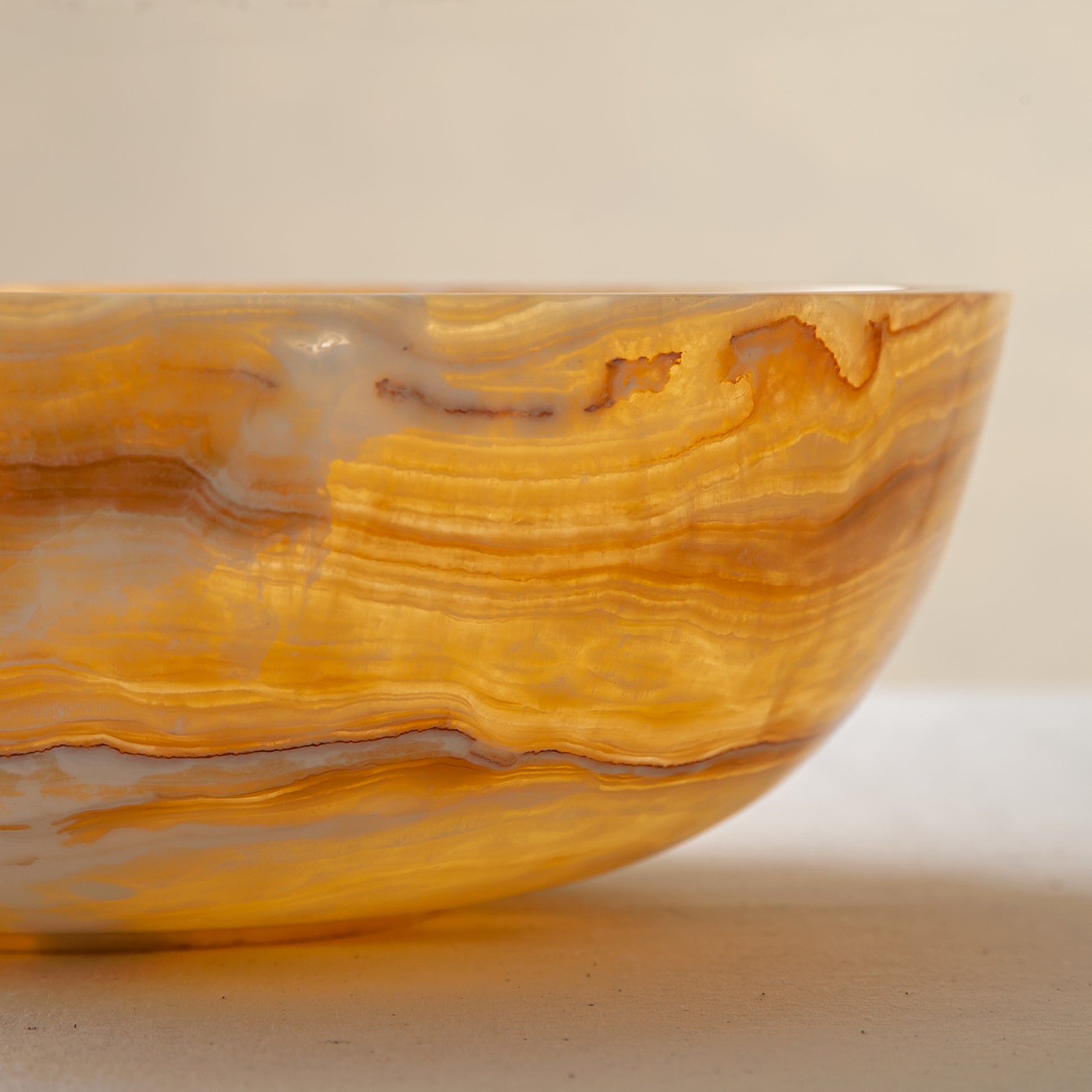 handcrafted onyx bowl with golden amber banded veining and smooth polished finish
