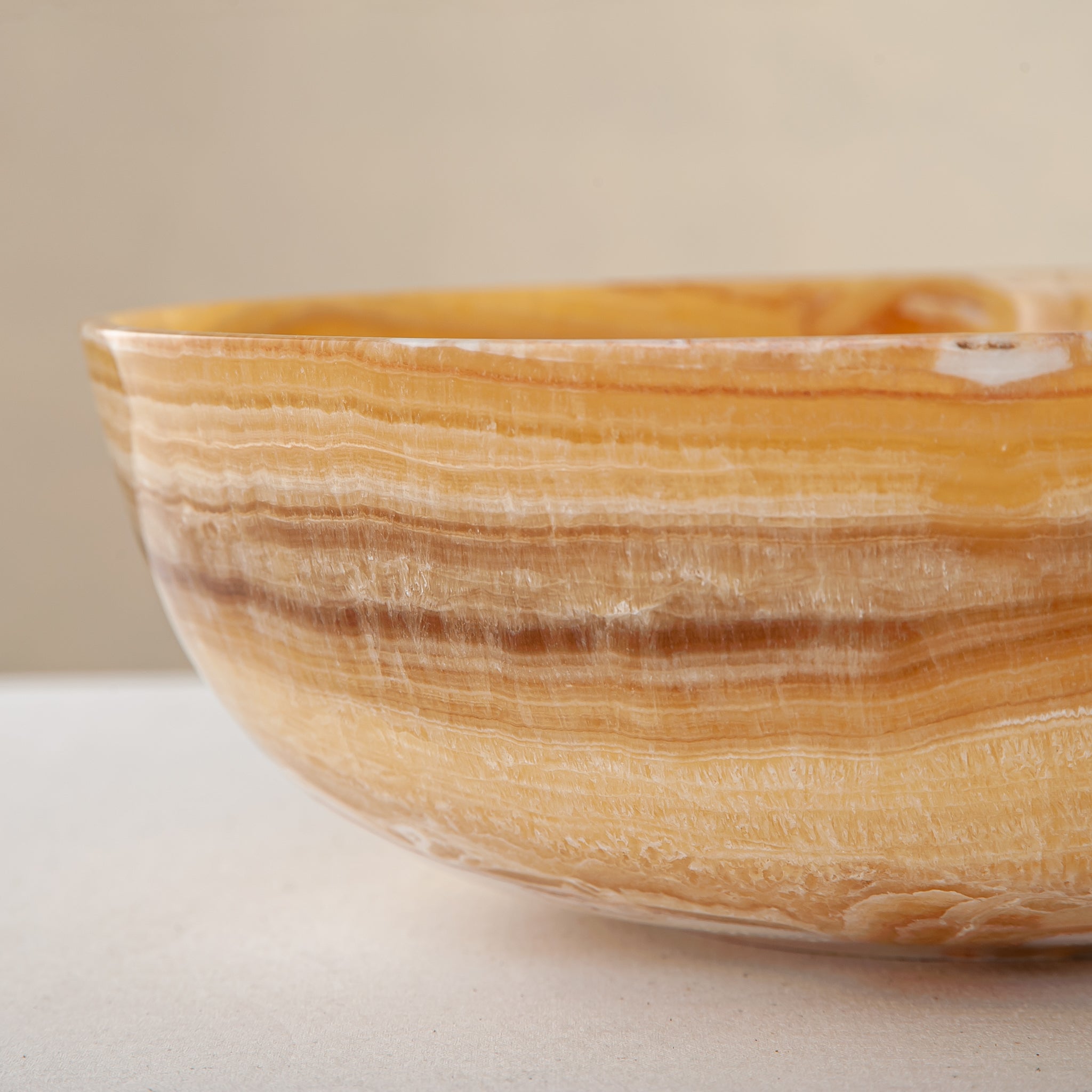 handcrafted onyx bowl with golden amber banded veining and smooth polished finish
