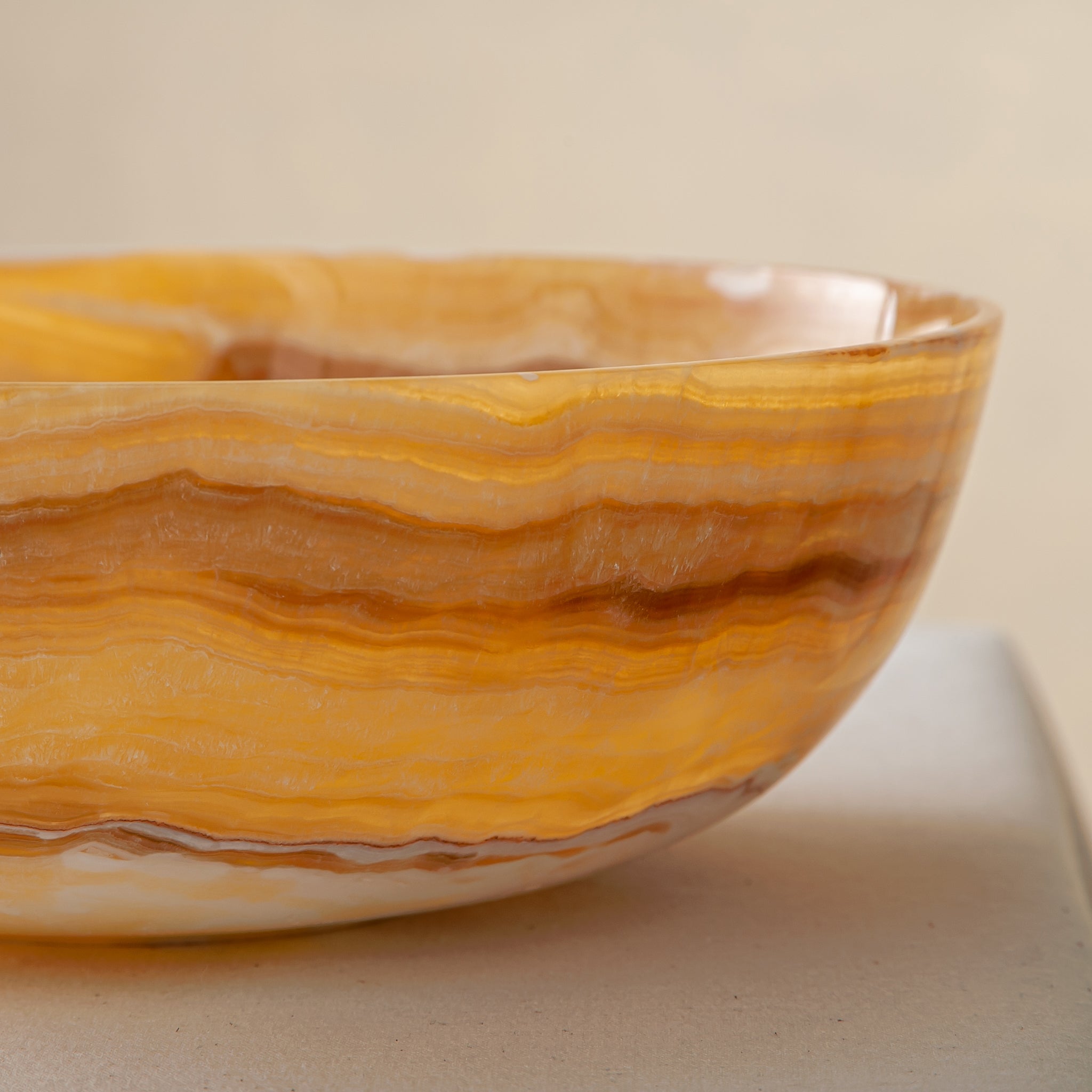 handcrafted onyx bowl with golden amber banded veining and smooth polished finish
