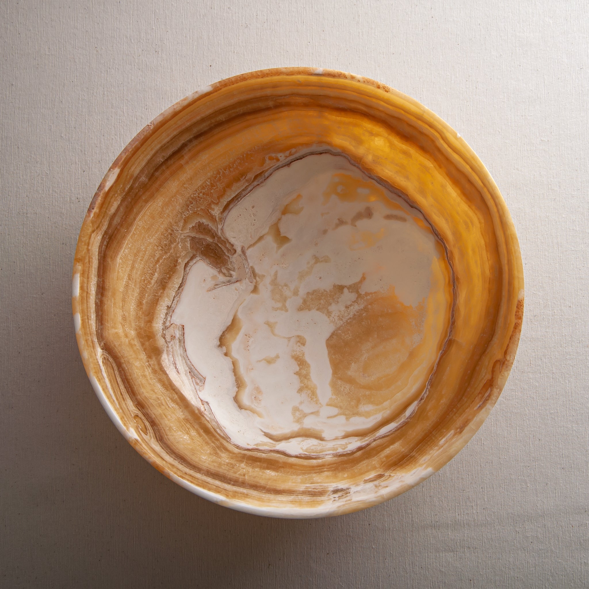 handcrafted onyx bowl with golden amber banded veining and smooth polished finish
