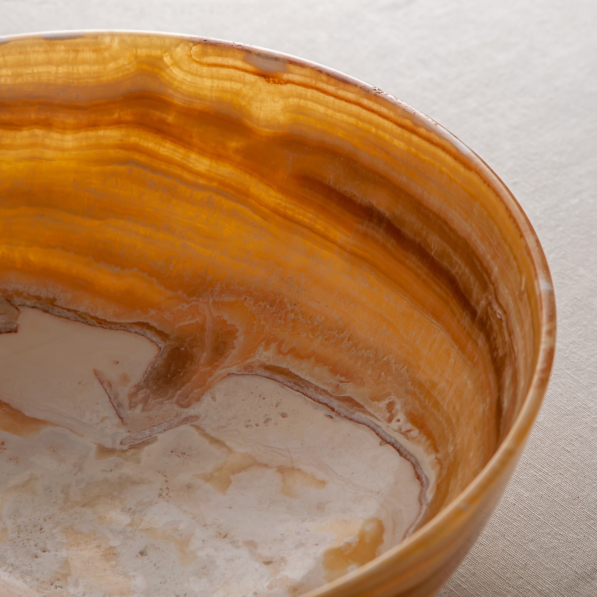 handcrafted onyx bowl with golden amber banded veining and smooth polished finish
