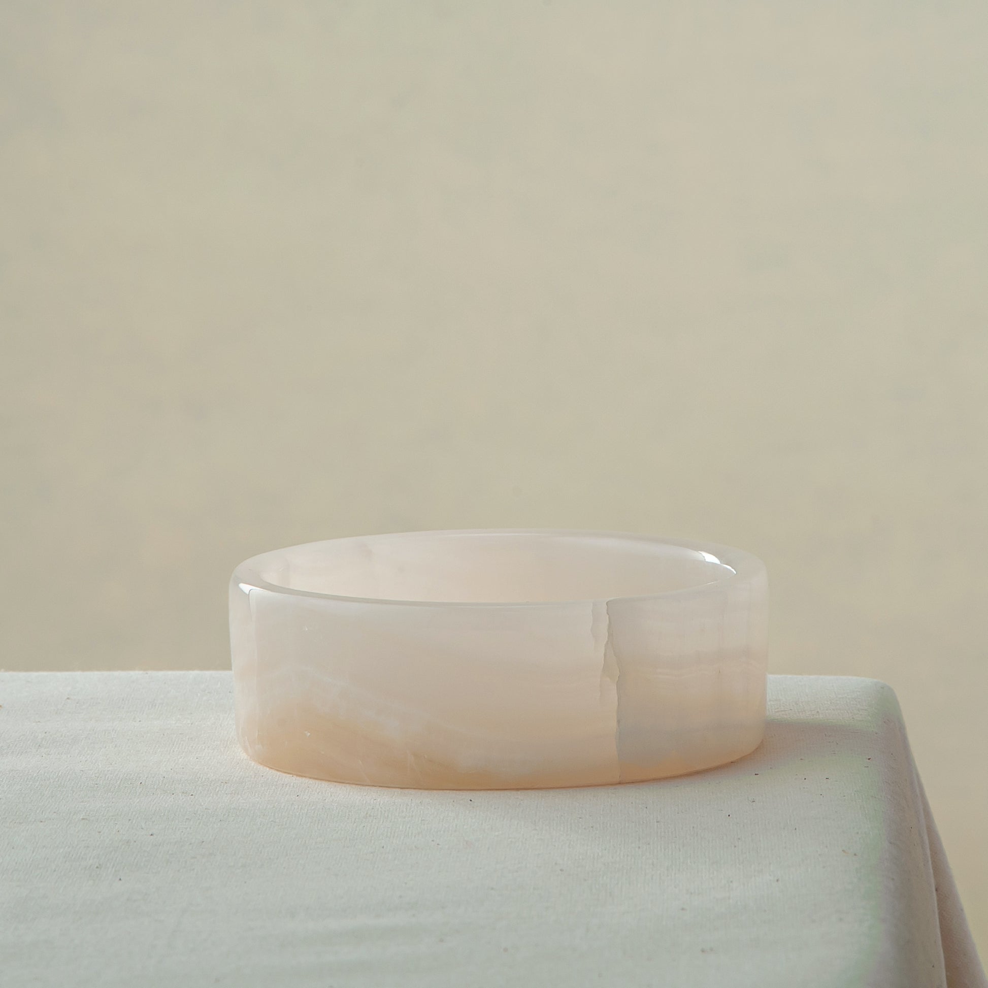 handcrafted onyx bowl in low cylindrical shape with soft white and blush tones for modern decor
