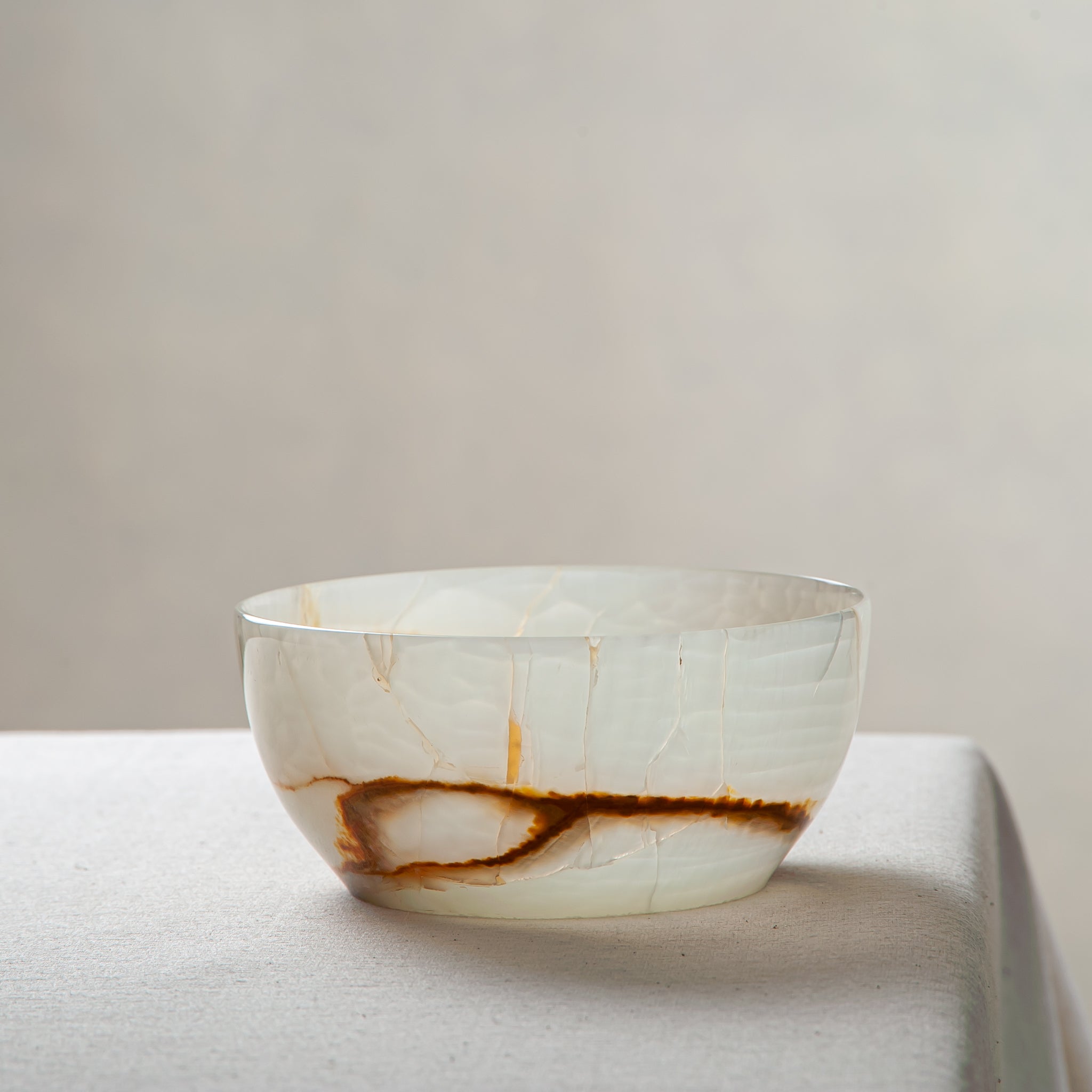 Unique natural onyx bowl with soft translucent surface and warm accent lines
