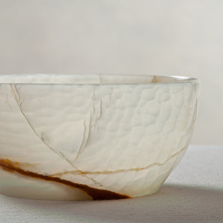 Unique natural onyx bowl with soft translucent surface and warm accent lines
