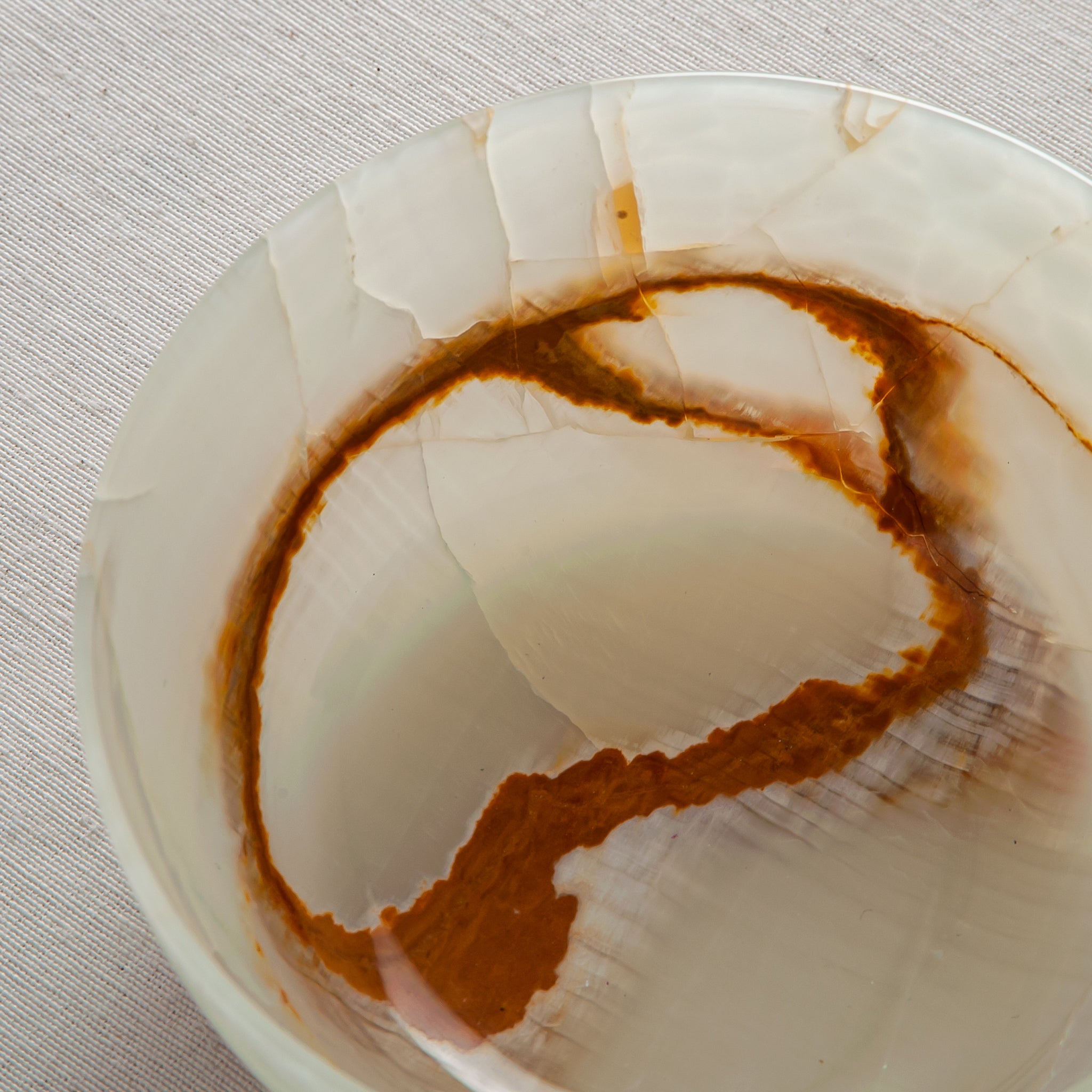Unique natural onyx bowl with soft translucent surface and warm accent lines
