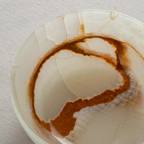 Unique natural onyx bowl with soft translucent surface and warm accent lines
