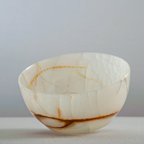 Unique natural onyx bowl with soft translucent surface and warm accent lines
