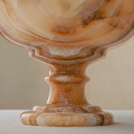 Unique natural onyx bowl with warm honey hues and elevated sculptural form for centerpiece styling

