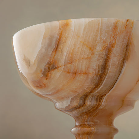 Unique natural onyx bowl with warm honey hues and elevated sculptural form for centerpiece styling
