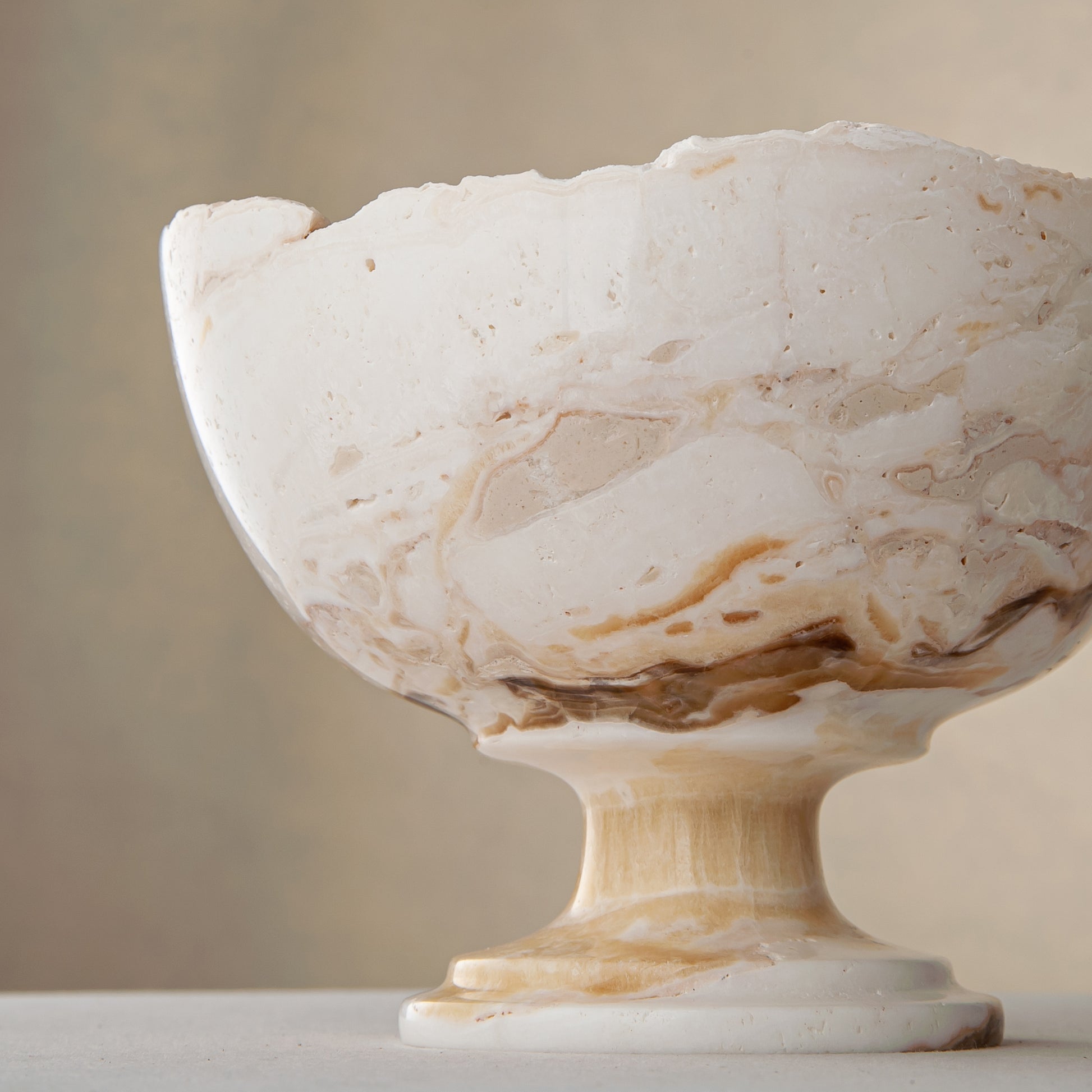 handcrafted onyx bowl with pedestal base in ivory tones and natural veining for luxury decor
