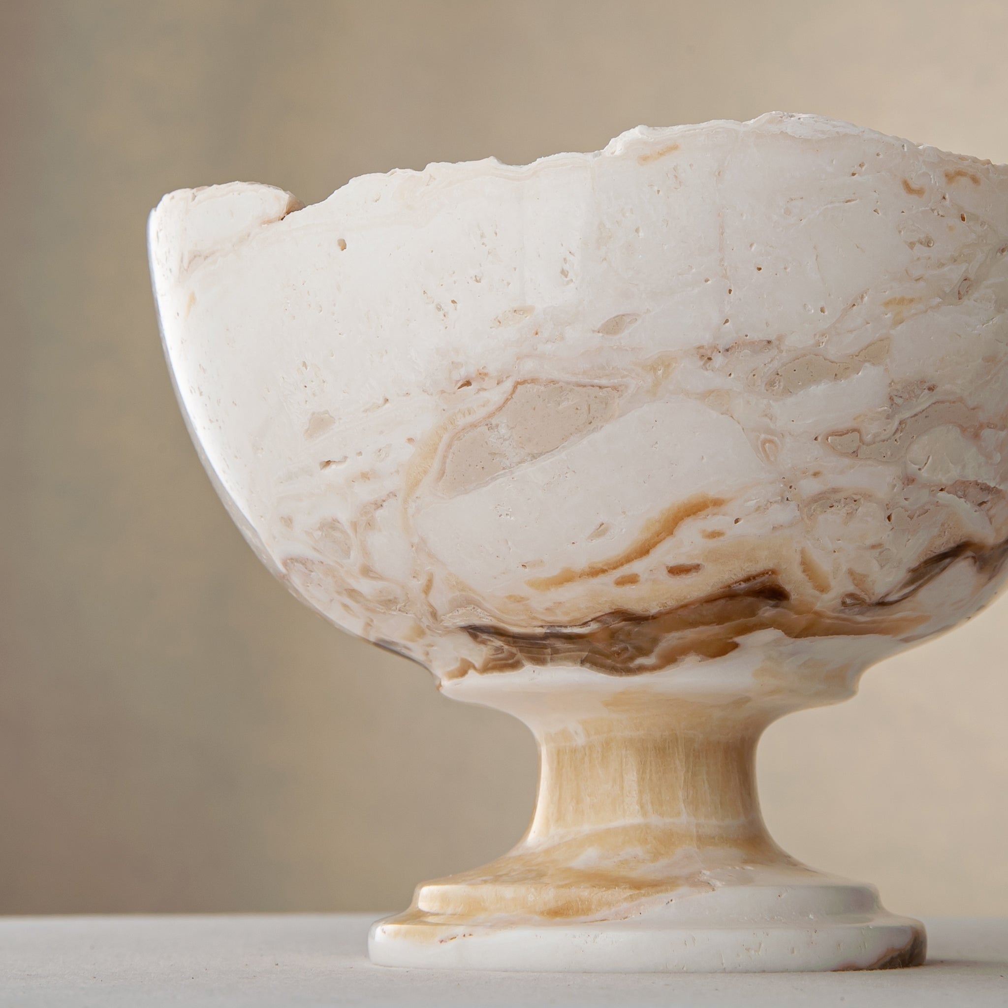 handcrafted onyx bowl with pedestal base in ivory tones and natural veining for luxury decor
