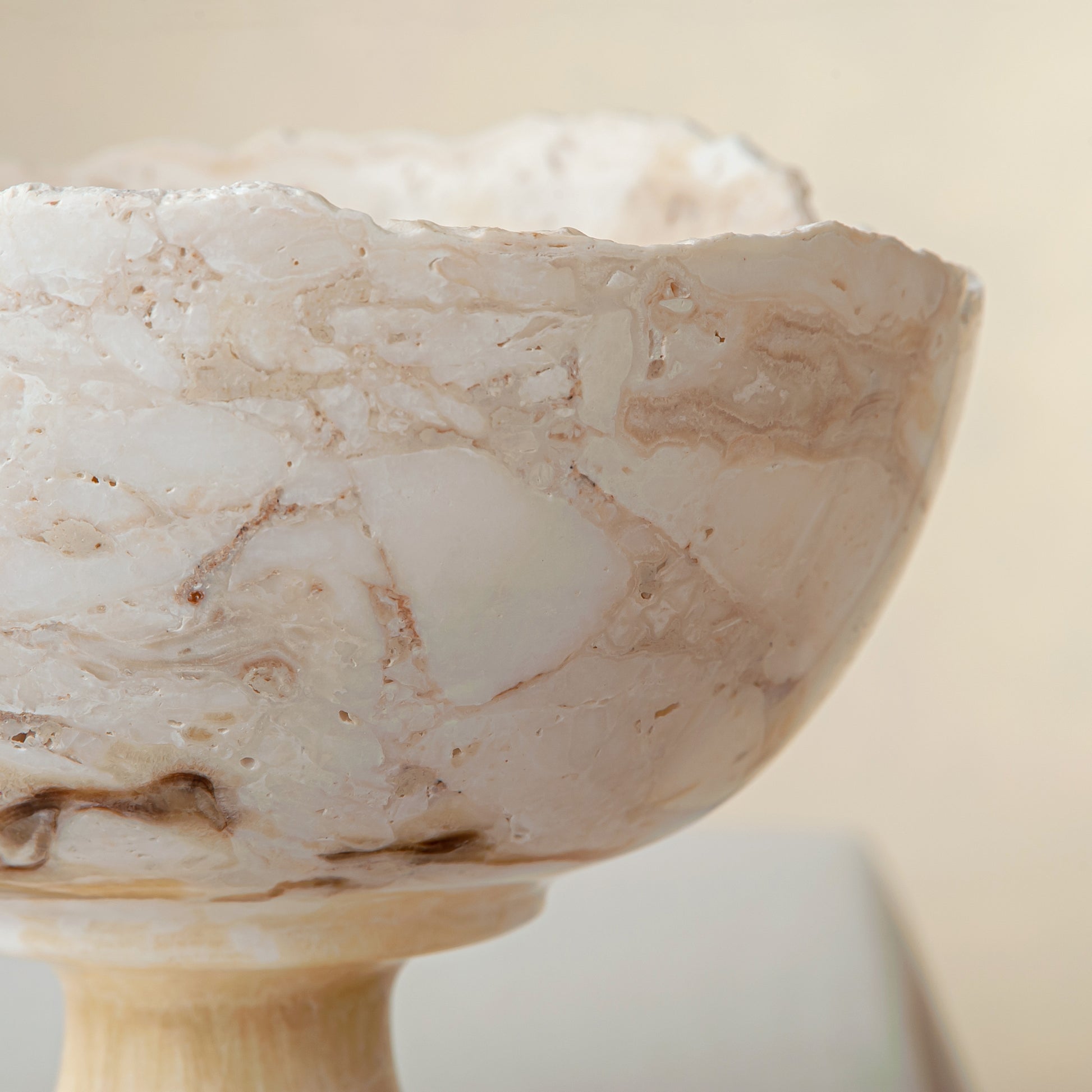 handcrafted onyx bowl with pedestal base in ivory tones and natural veining for luxury decor
