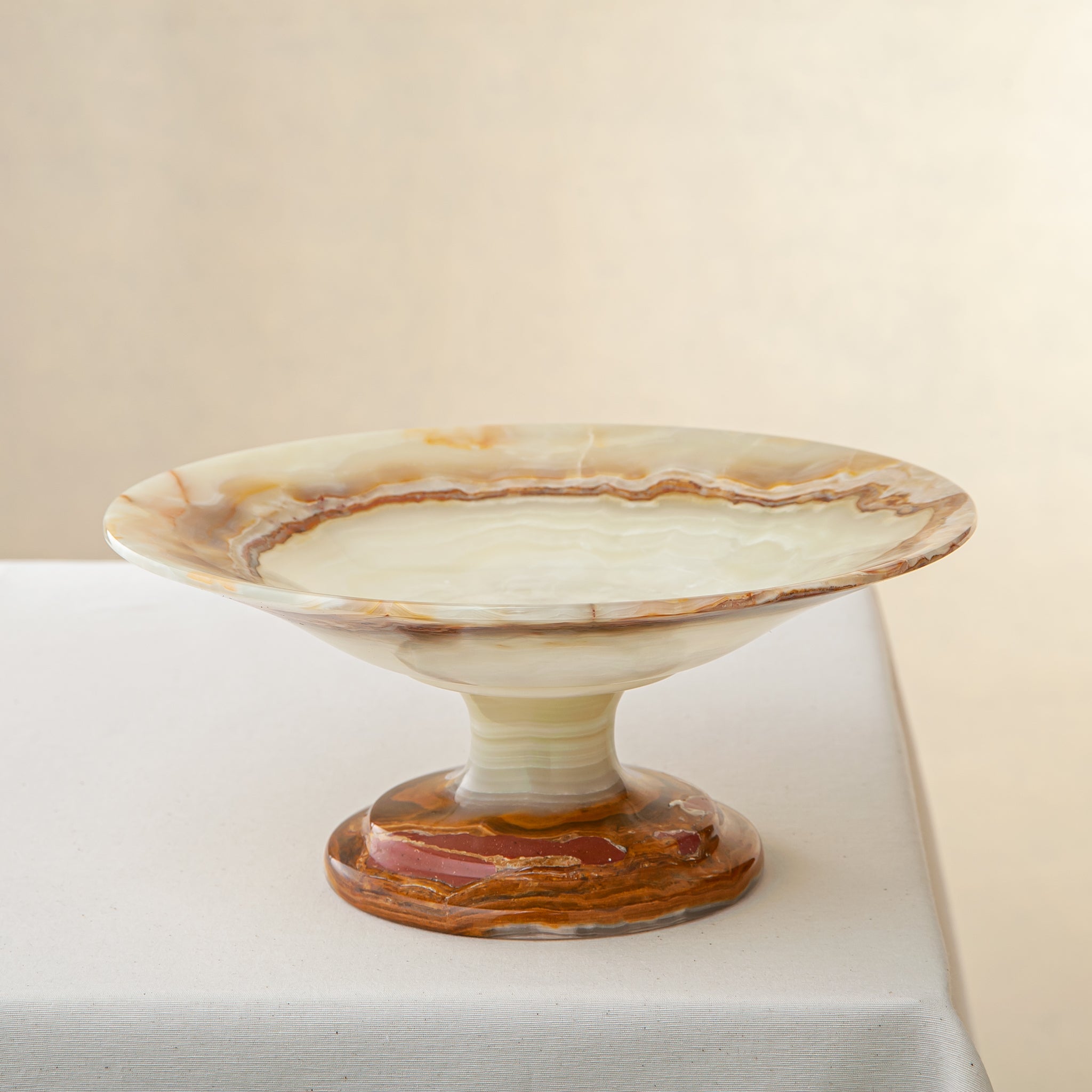 handcrafted onyx bowl with pedestal base and translucent layered amber veining for luxury decor
